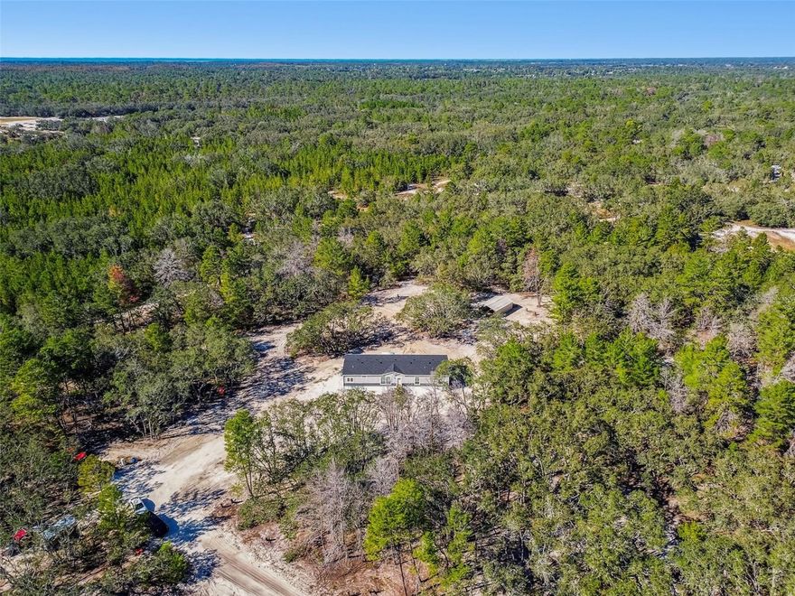 Opportunity Awaits. Here is a 2025 built home tucked away on 14.27 private acres in Hudson. With agriculture zoning and a future land use of RES 1 that allows one home an acre, this property offers incredible long term potential to build up to 14 homes. No wetlands and no flood zone provide peace of mind from day one.

Through the electric gated entrance, a private drive winds back to a beautifully finished 4 bedroom 3.5 bathroom home with 2,254 square feet of living space. Inside, the open concept layout lives large. The main living room flows seamlessly into a showstopper kitchen featuring an oversized island with barstool seating, stainless steel appliances, abundant cabinetry, and a generous dining area that is perfect for family gatherings and entertaining. Just off the kitchen, an additional family room creates a second comfortable hangout space and keeps the heart of the home connected.

The owner’s suite feels like a luxury retreat with a spa inspired bathroom that offers a freestanding soaking tub, separate walk in shower, dual sinks, and beautiful finishes. The massive walk in closet with a center island delivers the kind of storage that is hard to find. The second bedroom features its own private ensuite bathroom, ideal for guests, multigenerational living, or an older child who wants extra privacy. The remaining bedrooms are located nearby with a full guest bathroom conveniently positioned to serve both bedrooms and the main living areas. A half bathroom off the common space adds everyday functionality.

Outdoor improvements make this property truly turnkey. A brand new 1,090 gallon septic system and an 80 gallon well tank with a 2.5 horsepower pump service the home. An 18 by 32 pole barn provides covered storage for equipment, vehicles, or a future workshop. The acreage is naturally wooded and peaceful, offering plenty of room for animals, gardens, riding trails, additional homesites, or simply enjoying the quiet of your own private retreat.

With acreage, privacy, no HOA, no CDD, and the freedom to build out your vision, this property delivers both immediate comfort and future opportunity. Schedule your private tour of 12015 Gladwin Avenue and experience everything this 14.27 acre estate has. Refer to MLS ID TB8448550 for the Land Listing