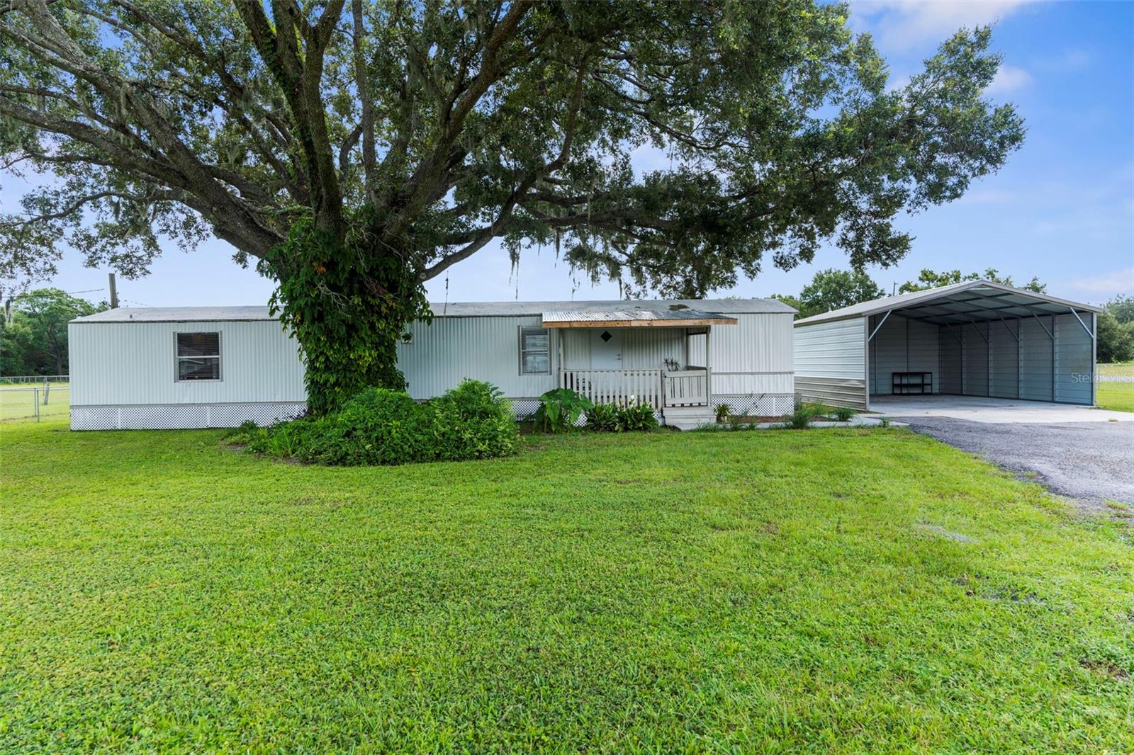 2 Bed, 2 Bath Mobile Home on 2.41 Acres Corner Lot – Zoned AG with Extras!
Enjoy peaceful country living on this 2.41-acre agricultural-zoned property featuring a well-maintained 2 bedroom, 2 bath mobile home. The home offers a split floor plan, spacious living area, and inside laundry. Outside, you’ll find two wood storage sheds perfect for tools or equipment, a metal carport for covered parking, and a chain-link fence surrounding the home—ideal for pets or added security. Plenty of grass for your animals and a great space for gardening. The pasture is partly fenced. With no HOA or deed restrictions, bring your toys, RVs, and animals—there’s room for it all! A great opportunity to live the rural lifestyle while still being close to town amenities and 11 mins to the interstate.