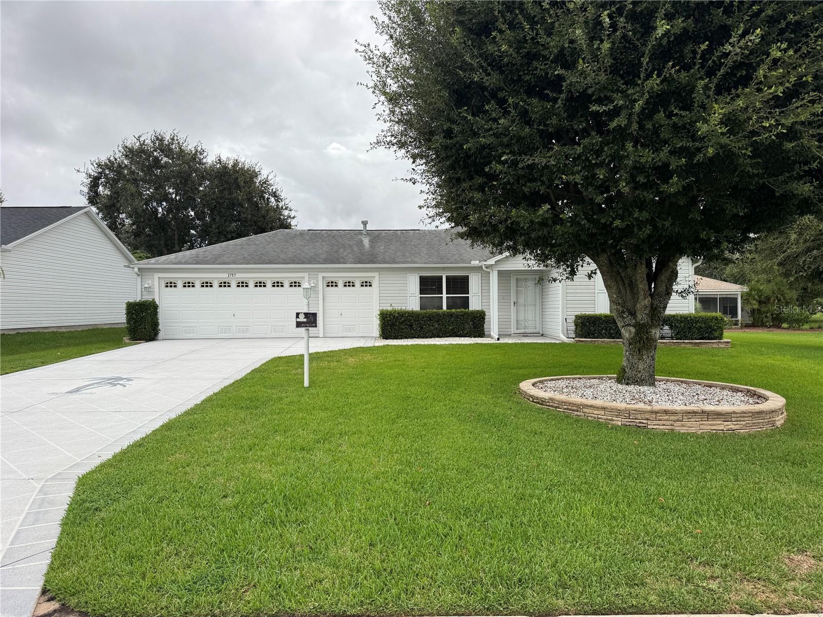 This beautifully maintained home offers thoughtful upgrades and is move-in ready! The two-car garage with a golf cart garage features a utility sink and washer and dryer. A long driveway welcomes you, complemented by mature landscaping and a quiet street location. Inside, enjoy Pergo flooring throughout the main living areas, tile in the bathrooms, and plush carpet in the bedrooms. The kitchen is a showstopper with quartz countertops, a gas stove, microwave, dishwasher, large corner cabinet for extra storage, and a skylight that floods the space with natural light. A breakfast bar with bar stools makes it perfect for casual dining. The custom master closet, Murphy bed with bedroom set in the guest room, and ceiling fans in every room provide both style and function. Relax year-round in the enclosed lanai under AC or enjoy the open lanai with ceiling fans. Additional highlights include a hot water heater (2017) and fresh interior paint. This home is conveniently located just minutes from Arnold Palmer Country Club, numerous shopping and dining options, and all of The Villages’ world-class amenities including championship and executive golf courses, pickleball and tennis courts, recreation centers, fitness facilities, and countless clubs for every interest. Low bond. Golf cart NOT included but for sale. Inquire.