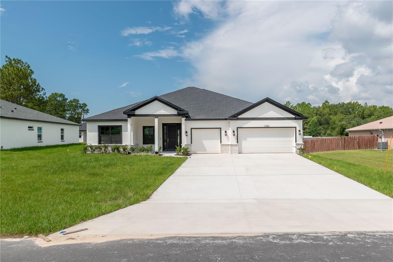 Ask about our Builder Incentives! High end luxury meets affordability in this stunning 4-bedroom 3-bathroom 3 car garage home situated on a central lot close to all things Ocala! From the moment you arrive you will notice the oversized driveway with ample parking and tasteful brick accents. Once inside, you will love the open floor plan with the living room, dining room and kitchen all flowing together in perfect harmony. The kitchen features 42'' upper cabinets, walk-in pantry, and an oversized island that is sure be the statement piece of this home. The Master suite is expansive with tray ceiling, dual sink vanity with beauty vanity station, huge walk-in closet, and gorgeous stone look tiled shower. Guest bedrooms are all very well sized with 2 bedrooms sharing a jack and jill bathroom with dual sinks. Indoor utility room with tons of natural light will make laundry your favorite chore. The secluded covered lanai is perfect for those enjoying the Florida relaxing with family and friends. Other STAND OUT features include Storm Proof Black Windows, Dolce White Quartz countertops, Samsung stainless steel appliances plus washer and dryer, 9'4'' ceiling & 8' doors throughout the entire home, Mohawk Ballard LVP flooring throughout the common areas, and so much more. This home won't last long, so schedule your private tour today before it's too late!