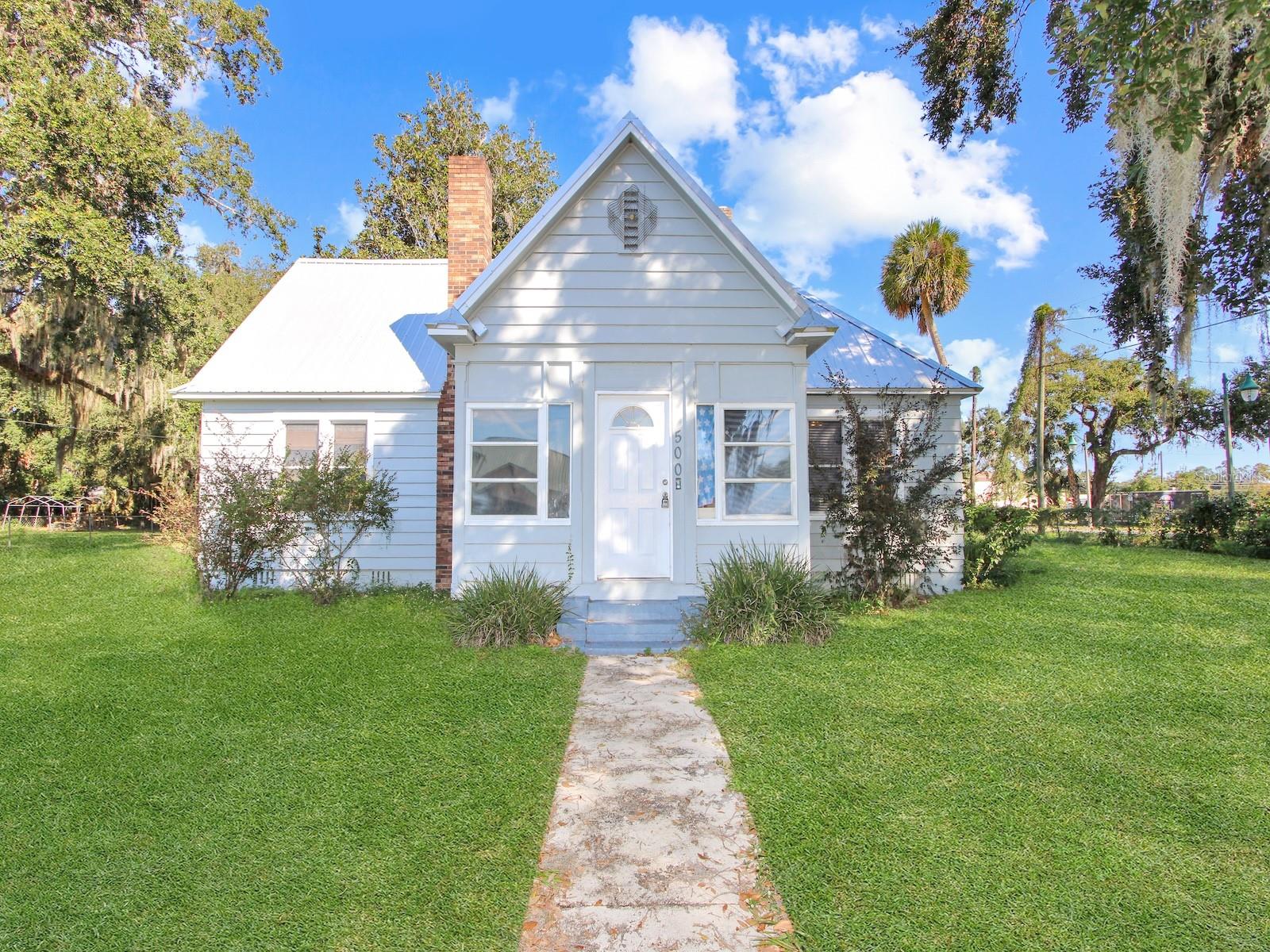 This appealing 3 bedroom 2 bath home is a rare Fruitland Park find. The liveliness of town center can be found within a comfortable driving distance. From the property, you'll enjoy inspiring views of City Hall. The trouble-free yard means more time to enjoy the place you call home. As you walk in, comforting features within will let you know you're home. Hardwoods gleam throughout, beneath a combination of stylish and natural lighting. The crackling fireplace imparts a cozy feel to the living room, creating a great spot for reading or a nap. The kitchen features inspiring counter space in an attractive layout. The entire scene looks great beneath warm natural light. The master bedroom is both an inviting vessel for drifting off to dreamland and a launch pad to begin tomorrow afresh. A gated driveway with ample accommodation for two vehicles leads to a detached two car garage w/ a workshop that is available for its original purpose or for conversion. The exterior and interior have been recently repaired and repainted, the home was rewired within the last two years, both the home and the detached garage had a new metal roof recently installed, and a new drain field just recently installed. Take the opportunity and make this home yours!