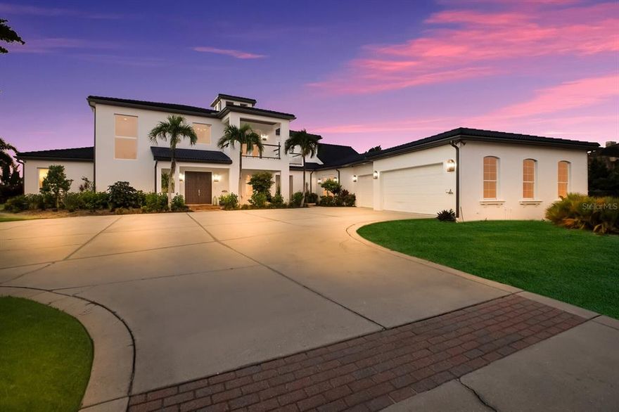 One or more photo(s) has been virtually staged. This beautifully updated waterfront estate is a boater’s dream, boasting a new extra-long dock, sprawling indoor-outdoor living spaces and stunning views of the Manatee River from almost every room. An expansive circular driveway surrounded by gorgeous tropical landscaping leads to the amazing  5-bedroom, 4.5-bath home, which underwent a complete West Indies-inspired exterior remodel in 2020 that included all new impact windows, sliders, French doors, new stucco, freshly painted gutters, inlaid wood tongue soffits with accent lighting, landscaping, custom power gate and a privacy wall. A whole-house Generac generator also was installed, and the tile roof was replaced in 2019. Savor captivating views from the oversized heated pool overlooking the river and dock, which previously held a 63’ vessel and has a new 10,000-lb. lift. The dock includes new electrical lines and boxes, Trex decking, fish prep station, security cameras, wrapped pilings, a spot to beach your Jet Ski or dingy and beautiful blue accent lighting at night. The residence’s interior has been thoughtfully updated, including all new wood oak flooring, a wrapping staircase, new millwork throughout and remote custom power shades in many rooms. Entertaining options include a custom movie theater with 115” screen, billiards room and spacious game room with a new wet bar kitchen. Covered waterfront lanais and a second-floor balcony also are perfect for entertaining and relaxing, with new remote-powered solar shade screens and high-end ceiling fans to keep you comfortable. The residence also has two generously sized primary suites – one on the main floor (elevator shaft in place) and one upstairs, which has been partially remodeled, as well as a gym, laundry room with two washers and two dryers, new tankless gas water heaters and full security system. This enticing home awaits just a few final touches to make it your own.