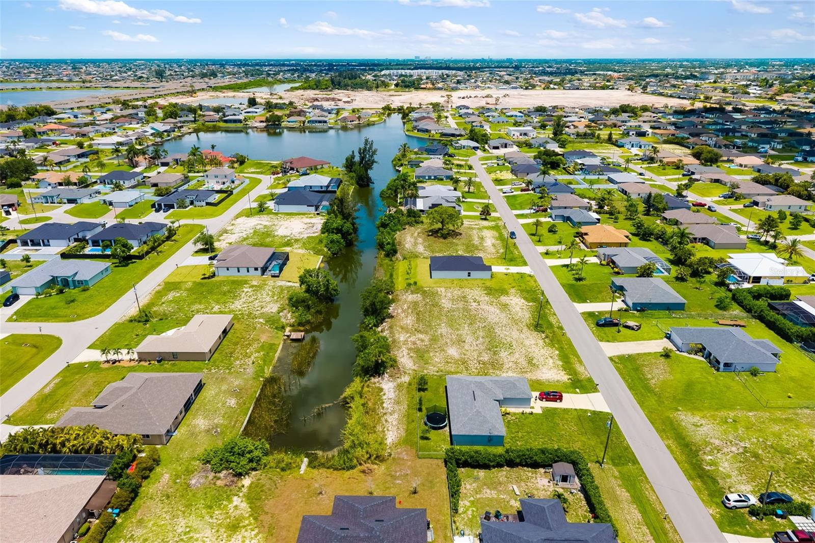 COASTAL FRESHWATER WATERFRONT LOT, known as the Honeymoon Lot, in one of Cape Coral’s fastest growing areas. Peaceful enclave of NW Cape Coral located at 1501 NW 2nd St. on Honeymoon Lake, easy access to Pine Island Road and Burnt Store Road, as well as the exciting new Tropicana and Crystal Parks, soon to feature public beaches. Enjoy the freedom of no HOA and the peace of mind that comes with being in Flood Zone X, LOW RISK FLOOD ZONE. A rare and emotionally rich opportunity to own a piece of paradise steeped in love, legacy and tropical serenity along the tranquil shores of Honeymoon Lake. Discover the allure of owning 0.23-acre lot, spanning 10,019 sq. ft (85 ft frontage x 125 ft Depth) CITY WATER & SEWER already available. Rectangular lot offers plenty of space to build your dream FRESHWATER WATERFRONT home with room for a POOL, all in the heart of Southwest Florida’s tropical paradise. Perfectly positioned along the NOVA CANAL, this pristine vacant lot has a story to tell. Sixty-one years ago, two soulmates began their journey by purchasing this very land while on their honeymoon. Enchanted by the sparkling waters, swaying palms, and peaceful surroundings, they dreamed of building a home where love would live forever. While life led them to settle in a beautiful home just across the way, they’ve cherished this lot as a symbol of where their journey began in Florida, all while watching it every day and remembering where their shared vision, laughter, and lifelong devotion still lingers in the soft breeze and golden sunsets. Gulf access just a stone's throw away, PUBLIC BOAT RAMPS nearby provide easy navigation to Matlacha Pass, Sao Carlos Bay, and beyond into the GULF waters. Proximity to I41 and I75, local eateries, world-renowned beaches, North Venice, Siesta Key, Sarasota, South Fort Myers, Sanibel, Naples, Marco Island and Punta Gorda, SWFL International Airports, island adventures, and charming coastal towns. This lot captures the true spirit of Old Florida with all the conveniences of modern living nearby. Whether you're continuing a legacy or beginning your own love story, this property is more than just land, it’s a sacred canvas waiting for your dream to unfold, invest in a lifestyle. Contact us today to walk this timeless property and feel the love still rooted in its soil.
