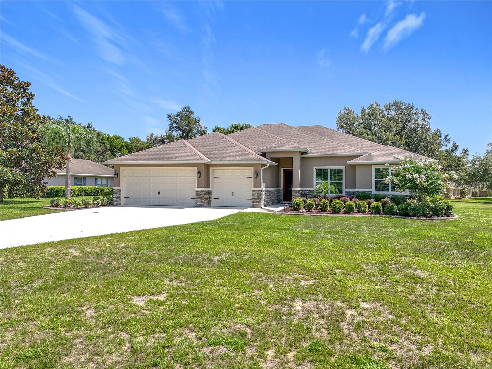 Welcome to 24041 Milford Drive, a beautifully built 2020 custom home nestled in the desirable Black Bear community of Eustis. This spacious 4-bedroom, 3-bathroom residence sits on a generous 0.76-acre lot and features a 3-car garage, offering the perfect combination of style, functionality, and room to grow. Inside, you’ll find a bright and open floor plan with high ceilings, wood look tile plank flooring, and a thoughtfully designed layout ideal for both everyday living and entertaining. The gourmet kitchen is a showstopper, complete with shaker-style cabinetry, granite countertops, stainless steel appliances, a large center island, and ample storage space. The primary suite offers a peaceful retreat with a walk-in closet and a spa-inspired en-suite bathroom featuring dual sinks and a walk-in shower.
Additional highlights include three well-sized guest bedrooms, two additional full bathrooms with modern finishes, a dedicated laundry room, and a covered rear lanai perfect for enjoying Florida evenings. The oversized lot provides plenty of space for a future pool or simply enjoying the peaceful setting. Located on a quiet paved road in a well-kept neighborhood, the reasonable HOA fee has several community amenities including internet and cable. Inside the garage there are two storage rooms, one with AC and one without making great space for storing your lawn equipment and holiday decorations.
Conveniently located just minutes from the new Wekiva Parkway, this home offers an easy commute to Orlando while still providing the privacy and charm of country living. Nearby shopping, dining, and entertainment in Eustis and Mount Dora make this an ideal location for families, professionals, or anyone seeking a quality home in a serene setting. Don’t miss this rare opportunity to own a move-in-ready custom home on nearly an acre in one of Eustis’ most attractive communities.