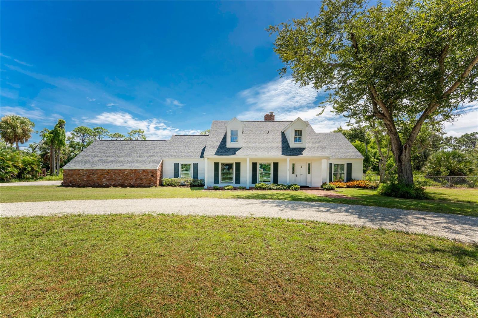 This could be the unique estate home you've been searching for! If you yearn for something different, then take a look at this classic-style 4 bedroom/ 2.5 bath two story home, situated on 1.67 acres in North Englewood. This custom built home is situated well back from the street, with a circular drive entry. The front porch covers you while you enter into an actual foyer, complete with slate floor. Both formal living and dining rooms have decorative chair railing/crown moulding and laminate flooring. The kitchen has updated cabinetry w/pull out drawers, granite countertops and a breakfast bar, perfect for your morning coffee. Appliances include: WOLF gas range, Frigidaire built in double oven, LG French door refrigerator and Kitchen Aid Dishwasher. The adjoining family room has a wood burning fireplace, great for ambiance or to actually warm up the room on those occasional cool evenings. The primary bedroom is thoughtfully located on the first level of the house, and features a large walk in closet, parquet flooring and ensuite primary bath, with completely updated granite-top vanity, lighting, shower enclosure w/seat & safety bars, and tiled flooring. There's a good-sized utility area, with washer & dryer tucked away behind closet doors, and separate half bath located in the same area. Upstairs you'll find three spacious guest bedrooms, all with carpeted flooring and a huge amount of closet space. The Guest bath has a combo tub/shower w/door, tiled flooring, & its own water heater. Oversized two car side entry garage has room enough for two cars plus all your garden tools! Huge tiled lanai is the perfect place to relax at the end of the day, or maybe for morning coffee! Large brick patio just off the Lanai would be the perfect place to add an outdoor kitchen. Zoned central heat/air systems for upstairs/downstairs were replaced in 2016 and 2019. Shingle Roof was replaced in 2022. Fenced back yard keeps the kiddos or the pets safe and contained. There's no pesky homeowner association telling you what you can and cannot do, either! (thus no fees!) This location is perfect - just a short distance to either Manasota or Englewood Beach, and local shopping, restaurants, and so much more! Application for Membership into the Englewood Gardens Beach Club is available, which has a private clubhouse, parking, security gate and beach on the gulf side and short term dockage on the bay side.