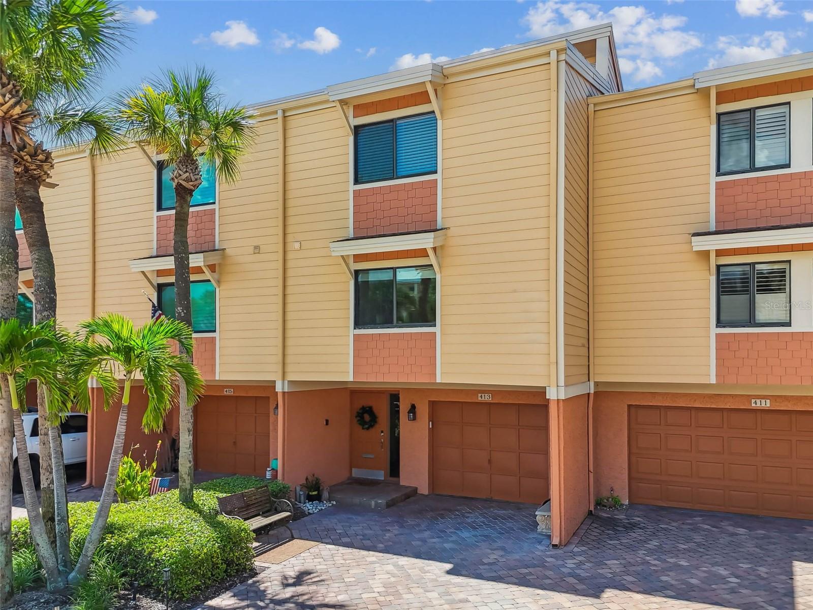 WATERFRONT TOWNHOME/CONDO – VILLAGES OF PARADISE ISLAND, Stunning waterfront townhome offering full marina and Intracoastal views! The open-concept living area features high ceilings, stone-faced fireplace, upgraded lighting, and sliding glass doors leading to a private balcony for dolphin and sunset watching. The kitchen includes granite countertops, shaker cabinetry, stainless steel appliances, walk-in pantry, built-in shelving and charming banquette seating, with accent lighting under cabinetry. Upstairs, French style entry doors open into the spacious primary suite which boasts vaulted cedar ceilings, custom closets, bamboo flooring and spa-like bath with jetted tub and walk-in shower. Impact rated sliding glass doors and plantation shutter window treatments, fold to one side to maximize natural light and scenery. Water views from your private deck overlooking the harbor and marina area provide a relaxing space to capture the sunsets. The second bedroom guest suite includes a full bath, quaint sitting area, wall to wall closets, window treatments and accent shelving. Laundry, storage, and attic access complete the upper level. Lower level offers a bonus room/den, oversized one car garage, and walk-out patio for closeup tropical water views of the intercoastal. Village of Paradise Island, a vibrant waterfront community designed for every generation. Cruise around in your golf cart, bring along your pets, and enjoy resort-style living right at home. Offers two spacious pools with shaded cabanas, a fishing dock, and a private launch for kayaks and paddleboards. Boating enthusiasts have access to 26 protected deep-water slips accommodating yachts and sailboats up to 45’. Slips are leased exclusively to residents on a first-come basis, with a short waitlist, at just $4/ft including water and electricity. Just a short walk or bike ride to Treasure Island Beach. Treasure Bay Golf and Tennis Recreation Center is next door and currently being renovated. Move-in ready—your waterfront lifestyle awaits! **NEW HVAC 2024, Hot water heater 2024, electrical panel 2023**Larger pets ok**HOA includes water, sewer, garbage, recycling, internet & basic cable, insurance (covers exterior, roofs, A/C units, common areas) repairs & maintenance (exterior roof, paint, siding, gutters, downspouts) landscaping & lawn care.