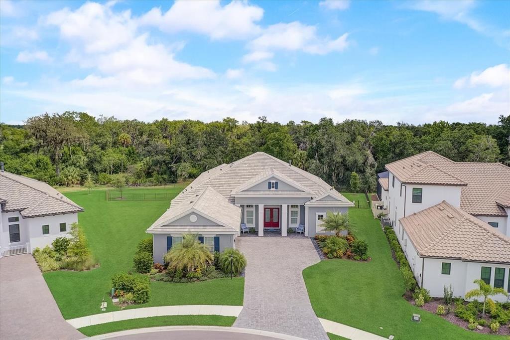 Resort-style living on one of the largest Preserve/Golf lots in Esplanade at Azario Lakewood Ranch! Built by Taylor Morrison, this stunning 3 bedroom, 3 and a half bath Smart Home (controlled by Alexa) offers a multitude of high-end finishes and upgrades. Immediately upon entry, looking through the great room there is a captivating view to the oversized covered screened lanai and pool. Watch sunrises and sunsets from the amazing Florida outdoor living area. The lanai area includes a beautiful heated pool with a water feature, spa, sun shelf and an outdoor kitchen complete with a gas grill, beverage refrigerator and a pizza oven! Bronzed aluminum fencing encloses the beautifully landscaped private backyard with a view of a nature preserve. Inside this gorgeous home, the open floor plan includes a great room featuring a fireplace surrounded by built-ins, crown molding, gourmet kitchen and dining area. The bright and spacious state-of-the-art kitchen features smart GE Cafe’ appliances, (including double ovens, cooktop, microwave, and a stately range hood), quartz countertops, marble backsplash and 12 ft. island with additional storage and a walk-in pantry. This home also includes a Den/Office and a bonus room that can be easily transformed to a home office, game room, or movie room. The master retreat is complete with two custom walk-in closets, direct access to the lanai, and his and hers zero entry walk-in showers. The second bedroom includes a walk-in closet with a private bathroom. The third bedroom features a walk-in closet and access to a full bathroom which doubles as a pool bath. The 3-car garage is finished with an AC, cabinets and hanging rack storage for all those “extra” items. Other enticing features are 3 AC units (home, master, garage), Hurricane impact windows, custom made wood shutters, 8ft. solid core interior doors, video doorbell, paver driveway, side-load garage and many more upgrades. Esplanade at Azario is a maintenance free resort-style community featuring an 18-hole championship golf course and signature resort amenities including a Wellness Center, Culinary Center, Tennis, Pickleball, dog park, Bahama Bar, resort-style pools, state-of-the-art fitness center, sports courts and much more.