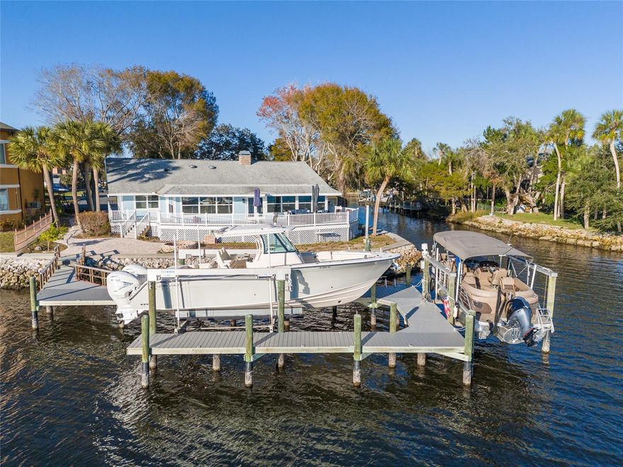 Check out the video tour link! BRAND NEW ROOF AND AC 2024!! *The main living area has NEVER FLOODED. Picturesque Florida coastal property!! A wide ramp allows ease of arriving at the front door without needing stairs or an elevator / lift. Experience waterfront luxury at its finest in this stunning Homosassa Riverfront home. Nestled in the exclusive Riverhaven Village at the end of a private cul-de-sac, this residence boasts over 290 feet of waterfront, offering unparalleled open water views. As you step through the front door, a breathtaking panorama unfolds before you, capturing the essence of tranquility with a seamless blend of windows, water, and nature. The property features a meticulously landscaped deck with a fire pit, perfect for entertaining or enjoying quiet evenings by the water. Additional enhancements include deck and dock lighting that illuminate the surroundings, creating a magical ambiance. A walk-around dock on the Lagoon side enhances the allure of this exceptional home, providing even more opportunities to soak in the captivating waterfront scenery. Inside, the interior is a masterpiece of design, featuring an open floor plan and a unique cupola room with vaulted ceilings. The wood-burning stone fireplace adds warmth and character to the space. The custom kitchen is a chef's dream, equipped with hickory wood cabinets, quartz countertops, and stainless steel appliances. A spacious sitting/family room provides a comfortable retreat to enjoy the water views, while a grand dining room sets the stage for memorable gatherings. The bedroom layout is thoughtfully designed, with three bedrooms and a bathroom on one side of the home, ensuring privacy for all residents. The primary bedroom, located on the opposite side, offers a walk-down shower, a walk-in closet, and elegant wood floors. The expansive laundry room and mudroom provide practical convenience, leading to a generously sized garage capable of accommodating four cars or all your recreational toys. Outdoors, composite wood decks abound, providing the perfect vantage point to relish the waterfront lifestyle. The impressive dock boasts three boat lifts, including 16,000 lb, 6,000 lb, and a jet ski or small boat lift. Crafted with composite decking, the dock features water and electric connections, making it a haven for boating enthusiasts. Riverhaven Village residents enjoy access to The Club, a vibrant community hub offering an Olympic-size heated pool ideal for laps, water aerobics, or simply relaxing poolside. Active lifestyles are supported with three tennis courts (two lighted) and four pickleball courts, as well as a fenced children’s playground and a dedicated dog park. Inside, the clubhouse features a newly updated full kitchen, library, big screen TV, pool tables, ping-pong, and shuffleboard. Social activities abound with groups for Mahjong, Bridge, exercise classes, Bingo, and Poker, and the clubhouse is also available for private member events. This Homosassa Riverfront home is a rare gem, offering a lifestyle of luxury, serenity, and endless waterfront adventures. Call today and come see your waterfront dream home! OWNER FINANCING AVAILABLE!