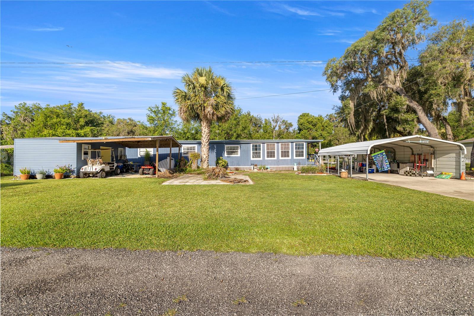 Please read Realtor Remarks for financing options. Welcome to Your Slice of Paradise in Salt Springs! Nestled in the heart of the Ocala National Forest, this beautifully upgraded and expanded home offers the perfect blend of comfort, functionality and Florida charm. Don’t be fooled by its single-wide beginnings—this property has been thoughtfully remodeled and transformed into a spacious and inviting retreat. Step through the covered two-car carport and galvanized ramp into a cozy den, ideal for a home office, TV room, or relaxing hideaway. From there, enjoy a bright and open living and dining area that flows seamlessly into an oversized chef’s kitchen—fully renovated in 2023 with brand-new cabinets, countertops, appliances, and abundant storage and prep space. Gorgeous solid oak flooring adds warmth and character throughout. The bathroom was tastefully updated in 2021, and essential systems have been upgraded for peace of mind, including a new HVAC system (2021), water heater (2021), and durable metal roof for long-term protection. Step out back to your private, vinyl-fenced porch—perfect for sipping morning coffee or unwinding in the evening. The property also features an 16x20 powered workshop/storage shed with a covered overhang, ideal for hobbies, tools, or extra storage. Set on beautifully landscaped grounds, this home is located just one block from the community boat ramp—providing access to stunning Lake George, Florida’s second-largest lake—for only $100/year. Enjoy days filled with boating, fishing, swimming, or exploring nearby trails and springs. Conveniently close to the Salt Springs Marina, shops, restaurants, and more. Whether you're seeking a weekend getaway or a peaceful full-time residence, this well-maintained gem has it all. Motivated seller—schedule your private tour today!