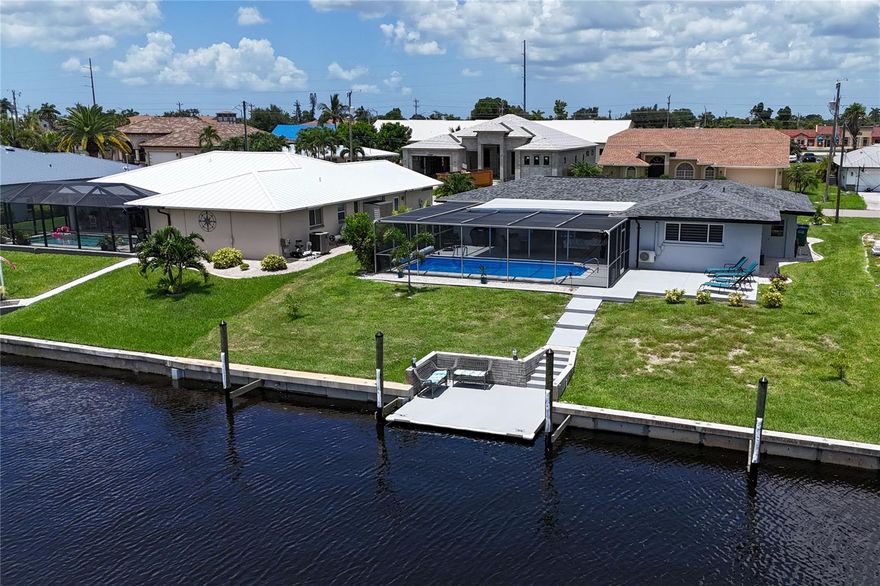 Welcome to your dream oasis in the desirable Palaco Grande Neighborhood, located on the picturesque Rainbow Canal! This stunning, fully remodeled pool home is offered completely turnkey, nestled in the sought-after Flood Zone X500 with no flooding concerns. Featuring impact windows throughout, this charming residence boasts a brand-new roof, AC, flooring, kitchen with quartz countertops, bathrooms, stylish window treatments, beautiful landscaping, and recent exterior paint. Step inside to an open floor plan with stylish furniture, offering a seamless flow throughout the home. Enjoy breathtaking views of the canal right from the front door. Massive sliding doors open to the lanai, providing the perfect setting for indoor-outdoor living. Perfect for boating enthusiasts, this property includes massive pilings for a large yacht and offers sailboat access with no bridges. The great entertaining space under truss is ideal for gatherings and relaxation. Additional features include a spacious 2-car garage and an extra patio with loungers and a seating area at the dock. Enjoy the convenience of utilities being paid and a proven rental history, making it an ideal investment or vacation home. With everything included, just bring your suitcase and toothbrush. One look, and you’ll be hooked. Don’t miss out on this incredible opportunity!