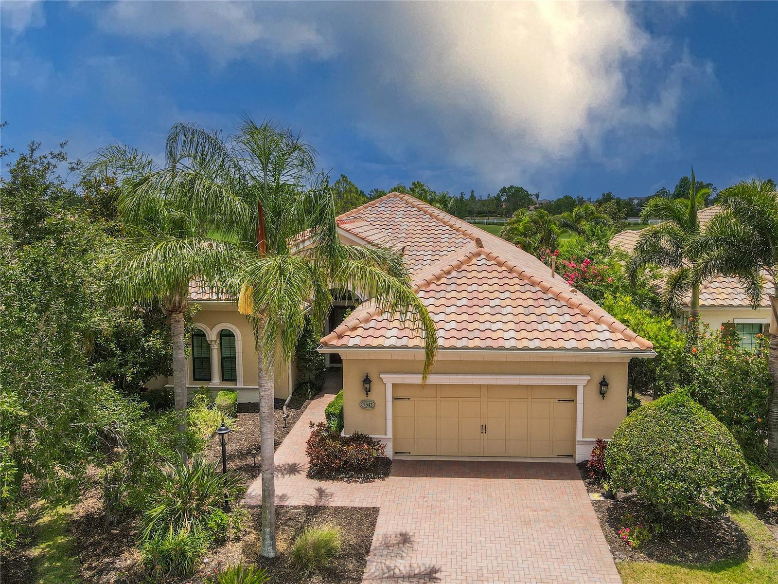 Best Priced Exquisite Golf Course Estate in Country Club East * Priced $50,000 below market value! This spectacular custom-built, maintenance-free residence, the "Chatsworth II" model, offers nearly 3,000 sq. ft. of luxurious one-level living within the exclusive, gated community of Country Club East. Ideally positioned on a premium southern exposure golf course lot overlooking the 10th fairway of Royal Lakes, this home boasts three bedrooms and two and one-half baths, privacy and breathtaking views. Rich architectural details abound, starting with the spacious entry featuring custom Therma Tru stain glass double impact front doors, an elegant tile inlay, designer porcelain tile flooring laid on a diagonal, and voluminous tray ceilings with expansive crown molding. The immaculate and expansive great room floor plan is designed for effortless entertaining including built-in Klipsch surround sound speakers. The generous kitchen is a chef's delight, appointed with towering 42" cabinetry (including roll-out shelves), exquisite Swarovski crystal lighting elements, warm granite countertops with a demi-bullnose edge, a marble stone backsplash, and GE Cafe Series stainless steel appliances, including a natural gas stove, oversized single stainless steel sink, and a butler's pantry with a wine refrigerator for the connoisseur. Ring video doorbell along with lanai camera and new LG TV's. Bask in natural light in the oversized master suite, which offers sweeping southern views of the golf course and pool through an expansive wall of windows. This private retreat includes two large, built-out walk-in closets and an en suite master bath featuring custom marble countertops, dual sinks set in a generous granite vanity, a garden soaking tub, and a spa-worthy walk-in shower with a Moen rain showerhead, hand-held slide bar, corner bench, and niche. The second and third bedrooms are generously sized for family and friends, complemented by a full spare bath. Double doors lead to a dedicated office/den with rich hardwood flooring. Step outside to your Florida oasis. Sizable sliding glass doors pocket out of sight, revealing a beautifully paver lanai with a screened-in, heated saltwater pool and spa. Enjoy the sun ledge in the pool while watching golf carts trickle by, or consider creating your dream outdoor kitchen with the pre-plumbed gas stub. Built to the highest energy-efficient standards, this home features a radiant barrier roof with a shield guard, high-efficiency "gold package" 16 SEER AC system, and spray foam insulation in exterior block walls, including the oversized 2-car garage. The laundry room, connecting the garage to the home, is equipped with Frigidaire appliances, a wash basin and copious cabinetry for additional storage. Located in the intimate enclave of Windy Hill within Country Club East, this residence is within walking distance to Lakewood Ranch Country Club’s Lodge, offering a full menu of delicious meals and access to three area community pools. Residents also enjoy access to the Resident-only Retreat Clubhouse with resort-style pools and a fitness center. Additional golf, tennis, and social memberships are available for those seeking a more active lifestyle. This stylish residence is wonderfully maintained and is ready for you to move in and enjoy the finest that Lakewood Ranch has to offer, with premier shopping, dining, and downtown Sarasota just a short drive away. Plan a visit – you’ll truly enjoy it.