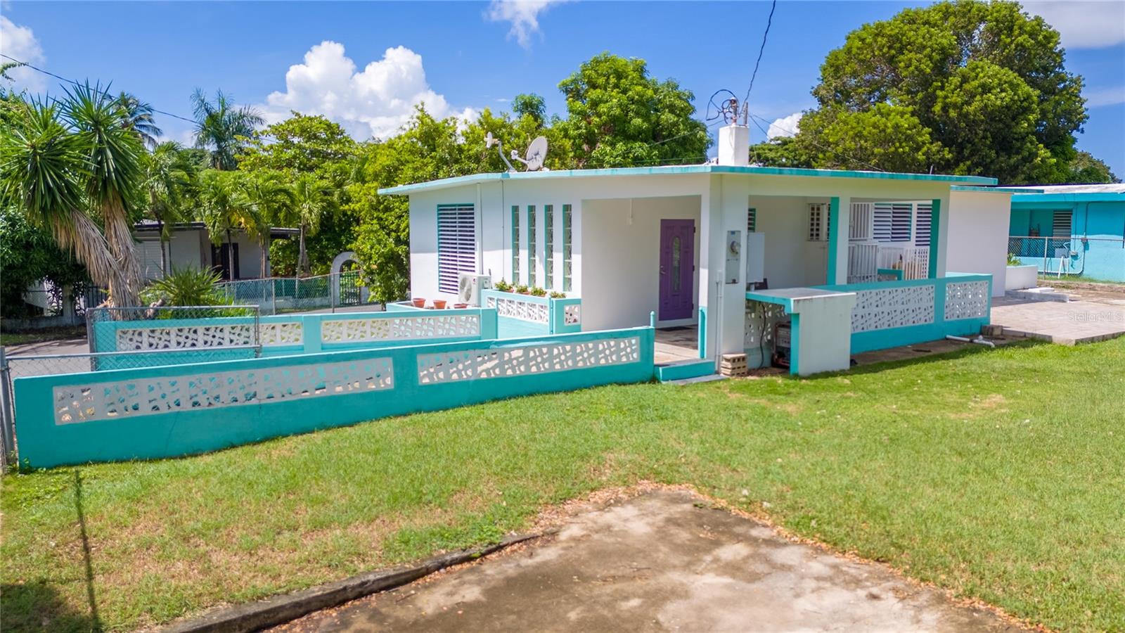 Charming Corner Lot Home in Vieques, Puerto Rico – 3 Bedrooms/2 Bathrooms with Spacious Yard!
This lovely 3-bedroom, 2-bathroom home sits on a 1/5-acre corner lot in tranquil Vieques. The property features a large fenced yard perfect for outdoor living, plus a concrete storage shed (168 sq. ft.) with water and electricity, ideal for extra storage, a workshop, or studio space.
Inside, the primary bedroom offers its own en suite bathroom for added comfort and privacy. Two of the three bedrooms are air-conditioned, keeping you cool during the warm island days. The large air conditioned living and entertainment area is great for hosting guests, and the bedrooms have plenty of closet space.
The yard is a gardener’s paradise with fruit trees—starfruit, banana, and mamey—giving you fresh produce from your own property. An old pig roast concrete frame serves as a raised bed where you can grow additional fruit and veg. There’s also a second gated parking area that can accommodate a boat, RV, or larger vehicle, offering extra flexibility.
As an added bonus, furniture and appliances are included at the list price, making this home move-in ready.