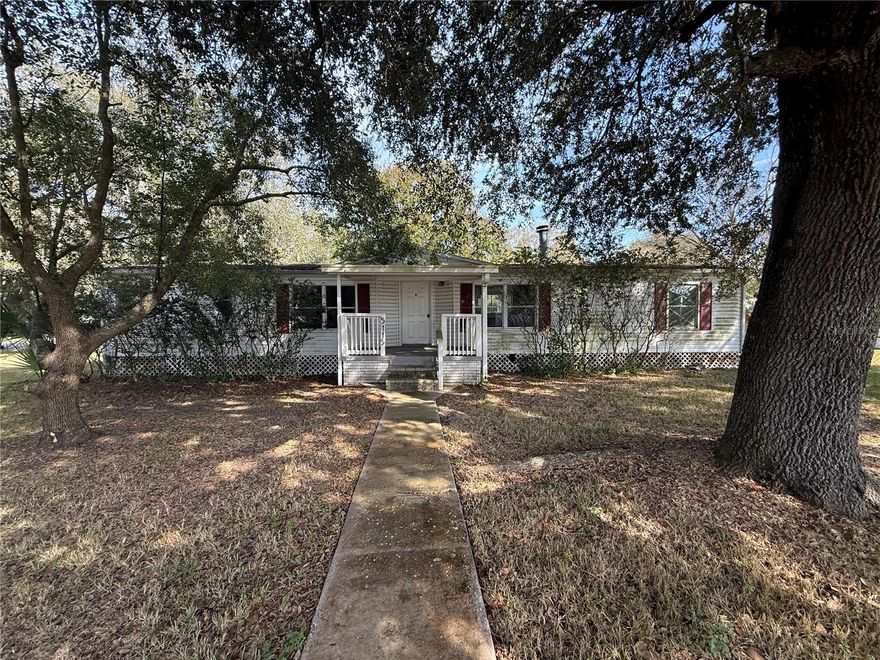 Situated on an oversized 1/4 acre corner lot, this well-maintained manufactured home offers 3 bedrooms, 2 bathrooms and a covered 2 car carport.  1,728 square feet of comfortable living space.  NO HOA, just quiet country living.  Inside, you’ll find a nice and open split floor plan- master suite on one side and all the secondary bedrooms on the other. The spacious family room flows seamlessly into the kitchen, which features modern white cabinetry, generous counter space, a center island with drop-in range, and a closet pantry. Just off the kitchen is a combination dining and living area, along with a bonus Florida room, providing flexible space ideal for entertaining, a home office, or relaxing year-round. The primary suite offers a true retreat with dual sinks, a soaking tub, a step-in shower, and a walk-in closet. Two additional bedrooms share a full bathroom. Centrally located with easy access to Interstate highways, shopping, dining, and everyday conveniences, this property delivers value, location, and opportunity. Seller Financing (Vendee) may be available. It’s good to be home.