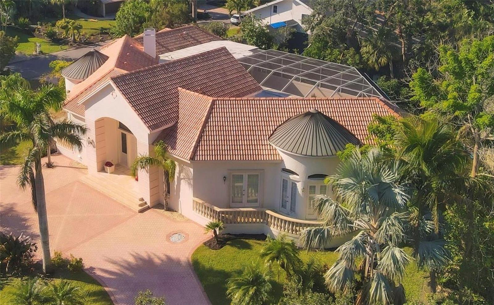 Immerse yourself in the tranquility of 5331 Siesta Cove Drive, a stunning jewel situated on a corner lot in the premier Siesta Key neighborhood. With a Mediterranean architectural aesthetic that radiates finesse, this residence features a stunningly crafted exterior adorned with European copper domes perfectly poised on an impressive 11’ elevation. Upon entry, one is greeted by an expansive, open concept living space that magnificently fuses the indoors with the surrounding natural beauty. High sweeping ceilings create an enviable sense of space and light, while polished ceramic tile flooring adds a touch of allure.
Thoughtful consideration has been given to the common areas, such as the lavish living room, with an undeniable emphasis on comfort and sophistication. The episodic, broad windows let the glow of sunshine in, accentuating the elegant interior nuances.
The kitchen is a veritable chef’s delight, replete with spacious cabinetry, and granitic countertops that inspire culinary creativity. The generous breakfast nook provides an intimate and cozy venue for smaller gatherings and casual meals.
Outdoors, discover a secluded oasis where the skies, the greens, and the water merge to deliver a serene atmosphere. The sprawling deck, overlooking a large, elevated swimming pool, provides ample room for sun loungers, and al fresco dining setup, with outdoor kitchen.
The residence’s strategic location in Siesta Key, FL, rewards its residents with convenient access to local amenities and landmarks. Enjoy being a stone’s throw away from stunning beaches, upscale shopping destinations, refined dining venues, and outdoor recourses.
5331 Siesta Cove Drive offers an extraordinary amalgamation of luxury living and the calm of a beachside residence. Its matchless design, location, and surrounding serenity make it an idyllic haven for those seeking an unparalleled lifestyle in Siesta Key.