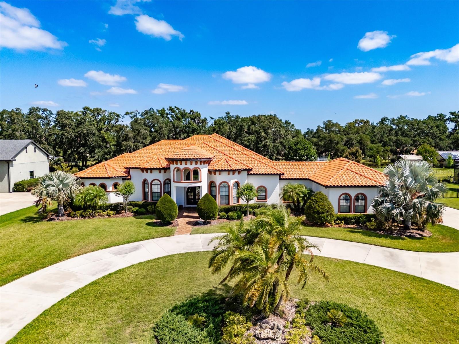 Stunning 4-Bedroom, 3.5-Bath Custom Home in Gated Hawk Creek Reserve. This beautifully upgraded 4-bedroom, 3.5-bath home—built by Bartlett Custom Homes—offers luxury, comfort, and thoughtful design in every detail. From the moment you arrive, you're welcomed by a travertine walkway and elegant wood front doors featuring glass and wrought iron. The curb appeal is enhanced by a circle driveway, a side-entry 3-car garage, a tile roof, lush St. Augustine grass, tropical landscaping and sits on 1.10 acres.
Inside, the chef’s kitchen is a true delight, boasting a 5-burner gas cooktop with a range hood, GE Profile appliances including a refrigerator with built-in osmosis system and Keurig coffee maker, and double stacked wall ovens. The kitchen features soft-close cabinets with pull-out drawers, a subway tile backsplash, a coffered ceiling, and an extensive island with a sink and bar top for casual dining. A spacious walk-in pantry sits conveniently nearby, and the bright breakfast nook overlooks the lanai through glass pocket sliders.
Entertaining is effortless with a butler’s pantry connecting the kitchen and dining room. The formal dining room features a coffered ceiling and a charming bay window. The open, airy family room offers soaring 16-foot box-beamed ceilings and additional pocket glass sliders that transition seamlessly to the lanai.
The den or office is generously sized, offering flexibility for work or relaxation. The owner’s retreat is a peaceful haven, featuring a spacious bedroom with ample natural light, two walk-in closets, and private access to the lanai. The luxurious en-suite bath includes a Jacuzzi tub, separate his and her vanities—one with a dedicated dressing area—and a walk-through shower with dual shower heads.
All secondary bedrooms in the home are large, with one offering its own private bathroom. There is also a convenient half bath located just off the family room. The laundry room includes a sink, a storage closet, and a hanging shelf, while the mudroom provides plenty of space for dropping off bags and shoes before entering the main living areas.
Beautiful wood plank tile flooring and custom shutters are found throughout the home. Additional premium features include a 22-kilowatt propane generator, a built-in Sonos sound system, two tankless on-demand water heaters, a whole-house water softener system, two A/C units, and spray foam insulation to help reduce energy costs.
Step outside to the expansive 1,200 sq ft lanai, finished with travertine tile and built for entertaining. It includes an outdoor kitchen and dining area, a sitting area perfect for lounging, and a massive sundeck that overlooks the large, sparkling saltwater pool. The fully fenced backyard provides plenty of space for dogs to play.
This home is located in the exclusive, gated neighborhood of Hawk Creek Reserve and is conveniently close to shopping and dining.