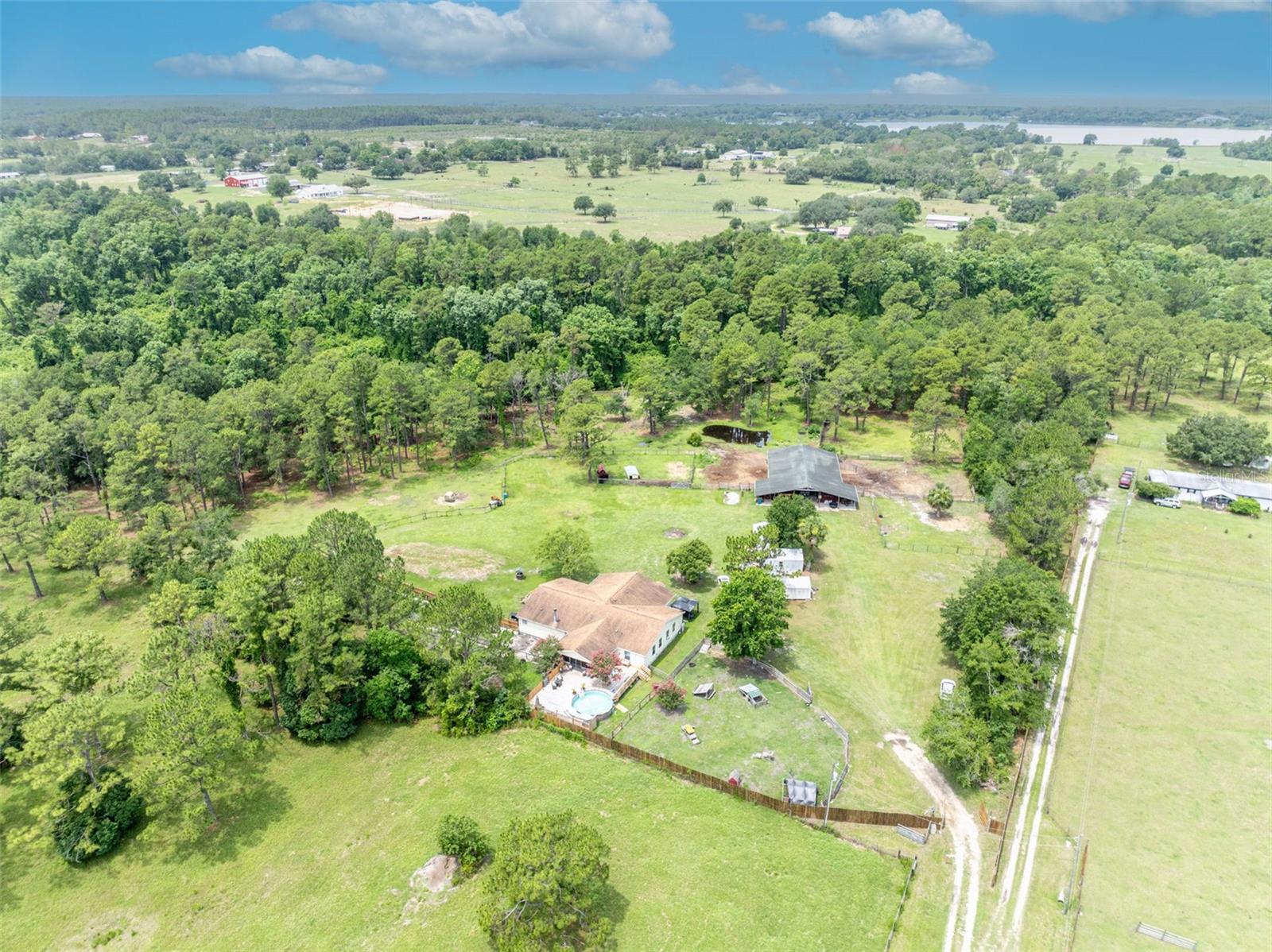 MOTIVATED SELLER. House is appraised $80,000 higher than listing price. That's $80,000 INSTANT EQUITY! My loss is your gain. Owner has paid for the survey and septic inspection. -- Looking for the perfect blend of country living and modern comfort? This stunning 4-bedroom, 3-bath home sits on over 12 acres—ideal for anyone who loves the outdoors or dreams of farm life. There’s plenty of space for horses, cattle, chickens, or goats, with top-notch facilities including a 3700 square foot under roof barn with 8 oversized 12x14 stalls, a 10x14 tack/feed room, and even enough room to drive a truck through the center. A covered patio and rinse pad add convenience for horse care.
The property is fully fenced and features a geothermal cooling system in the barn, three relaxing porches, and an electric gate for privacy and security. Inside, enjoy a beautifully upgraded kitchen, cozy wood-burning fireplace, new lights and fans throughout, and a bonus room off the primary suite that could be your dream office or expanded bedroom.
Cool off in the above-ground pool with a brand-new deck or explore the two ponds and three powered sheds (one with AC). With a 2018 roof, water softener system, and two AC units, this place is ready to go. Whether you're raising animals or just soaking in the peaceful vibes, this is country living done right.