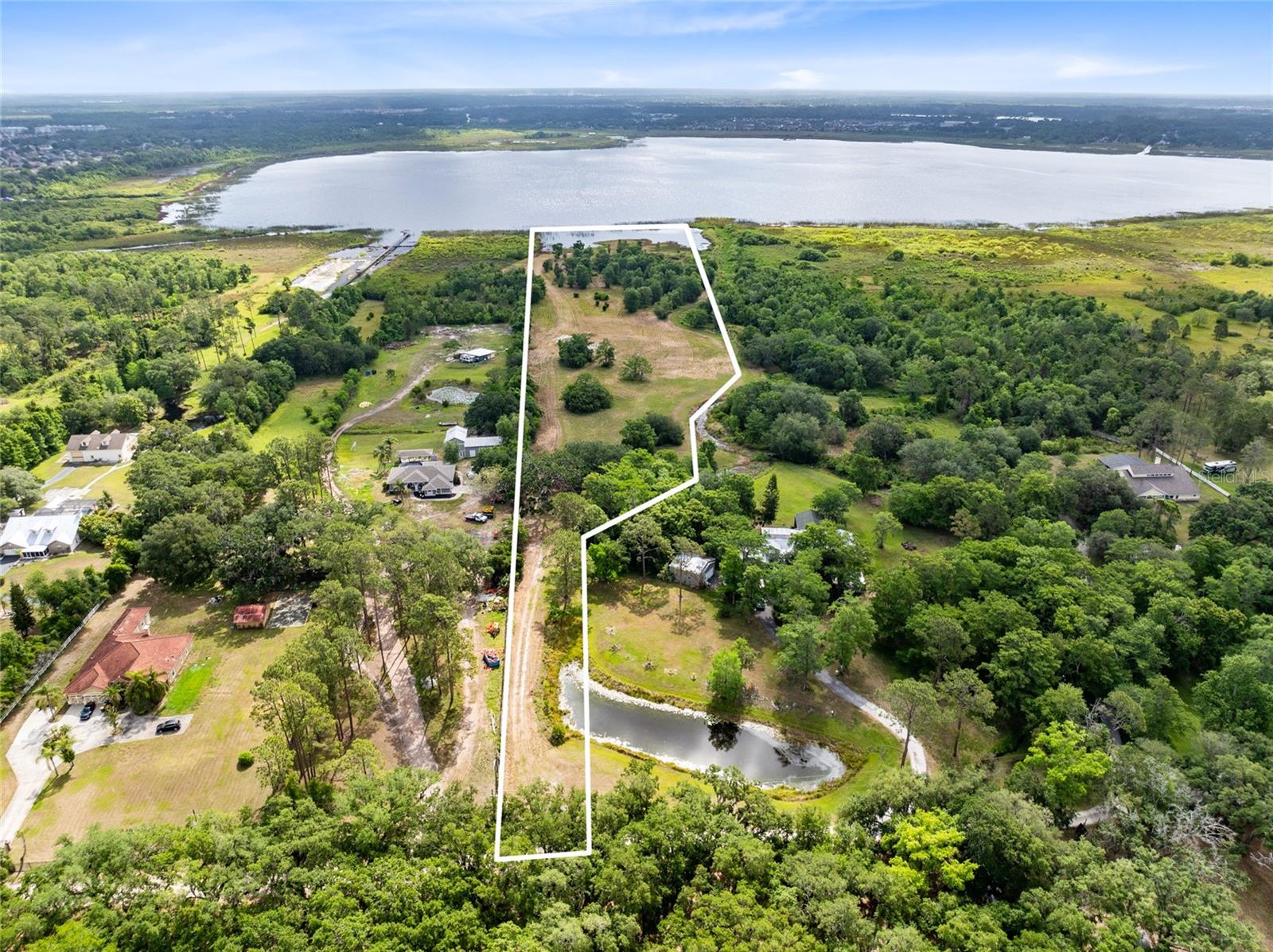 Experience the rare opportunity to own 5.82 pristine acres with over 373 feet of private lakefront on the serene waters of Fells Cove, part of the coveted East Lake Toho chain of lakes. This exceptional property offers a tranquil retreat with no HOA restrictions, allowing you to design and build your dream estate with the builder of your choice. A ready-to-build dirt pad is already in place, making your vision one step closer to reality. Nestled amidst abundant wildlife and natural beauty, yet just minutes from Lake Nona, Orlando International Airport, St. Cloud, and the VA Hospital, this one-of-a-kind offering perfectly balances seclusion and convenience. Whether you envision a luxurious lakefront residence or a private family compound, this property is a canvas for extraordinary living.