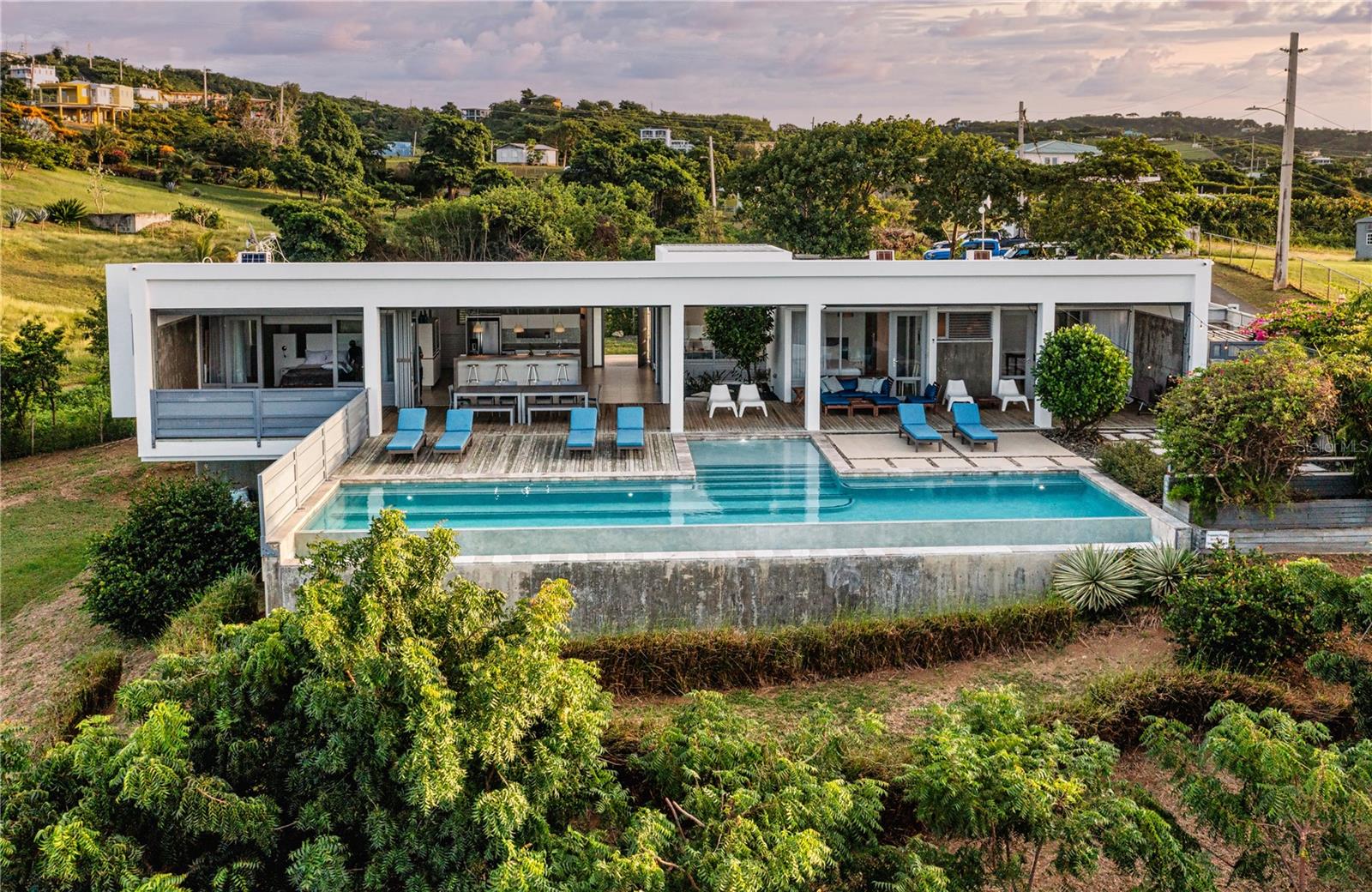 Introducing Casa Blue - A stunning mid-century inspired residence nestled on a lush tropical 3/4 acre parcel with stunning Caribbean sea views. This architectural gem boasts 4 bedrooms with en-suites, each offering a private retreat and an additional half bath for utmost convenience. The fourth bedroom is on a lower level and is a self contained apartment with it's own kitchenette, en-suite bathroom and tv space, perfect for an in-law, teenager or extended stay guests.
Designed with meticulous attention to detail, Casa Blue harmoniously blends modern luxury with mid-century charm. The spacious living areas are adorned with sleek lines, large windows and doors, and vibrant accents, creating an inviting atmosphere that seamlessly connects with the tropical surroundings and sea views.
The heart of the residence is its centerpiece - a 50 foot, refreshing swimming pool that becomes the focal point for relaxation and entertainment. Imagine unwinding in the tranquility of your backyard oasis, surrounded by swaying palm trees, tropical plantings, big ocean views to the North and the allure of nature.
Inside, the kitchen is a chef's dream, equipped with top-of-the-line appliances and stylish finishes. The bedrooms offer serene retreats, each with it's own character and access to the outdoor living spaces. The master suite, in particular, indulges with a private en-suite bathroom with both an indoor and outside showers and views that blur the lines between indoors and outdoors.
Casa Blue goes above and beyond, providing a plethora of extras to enhance your living experience. A full replacement generator ensures uninterrupted power supply. The outdoor barbecue area invites you to indulge in al fresco dining for unforgettable moments with family and friends. The property is fully fenced, enveloped by mature landscape that not only adds aesthetic appeal but also ensures privacy. There is covered parking and plenty of storage options from closets to cleverly placed cabinets. The property is entered through electronic access control and has a security system for monitoring the home. The house has the lasted technology in windows and door and there are storm shutters offering an added layer of preparedness. Additionally, there is space to build your very own tennis or pickle ball court.
As an enticing bonus, Casa Blue comes fully furnished with the exception of a few personal items and artwork.
Casa Blue transcends the ordinary, offering a lifestyle that merges elegance with the pleasures of tropical living on Vieques Island. Discover your own private paradise in this meticulously crafted mid-century inspiration.
Casa Blue is a testament to thoughtful design and elevated Vieques Island living.