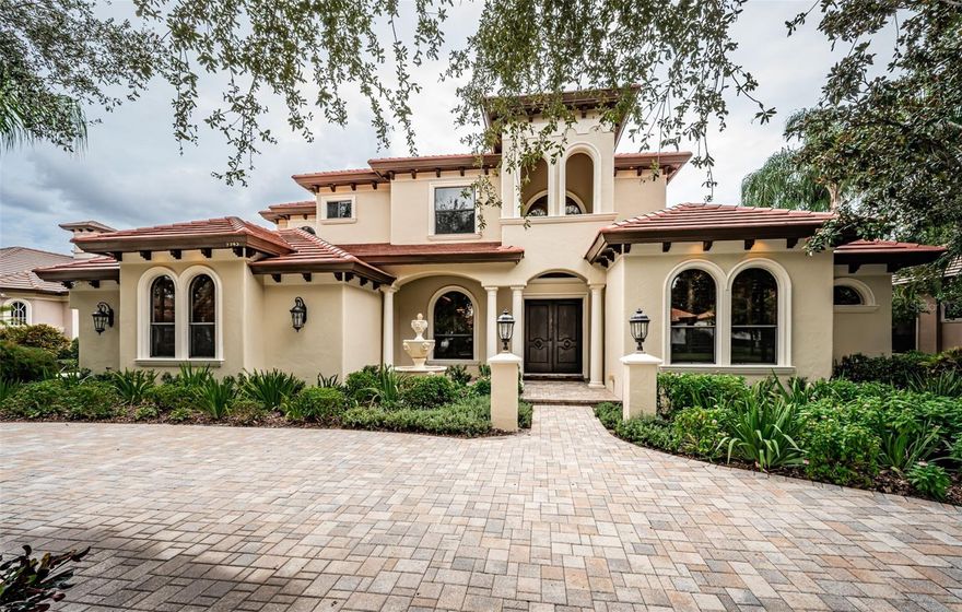 Welcome to your Tuscan dream home! Unique opportunity to own, one of just a few, Campagna  custom-built homes in Champions Club.  This luxurious Mediterranean  pool home is perfectly positioned on a premier homesite, offering breathtaking views of the Fox Hollow Golf Course and a serene lake. Over 4,600 SF of elegantly designed living space, this residence features 4 spacious bedrooms, a dedicated den/office, 3 full/2 half well-appointed bathrooms, multiple living areas including a grand great room, formal dining area and an open floor plan ideal for hosting gatherings. Step inside to discover a masterpiece of architectural design with exquisite details such as the impressive 21-foot vaulted ceilings adorned with crown molding and wood beams, travertine flooring, three cozy fireplaces, and a versatile bonus/media room and two grand staircases leading to the upper level.  The gourmet kitchen is a chef’s delight with upgraded Thermador stainless steel appliances, 6 Burner Gas Range, premium cabinets, and granite countertops. The oversized owner’s suite is a true retreat, featuring two custom walk-in closets, dual sinks with granite countertops, a walk-in tiled shower, and a luxurious garden tub. Each of the three additional guest bedrooms offers ample space and walk-in closets.  Entertain in style with an outdoor oasis that includes a sparkling pool with a spa, pavered lanai, and a fully equipped outdoor kitchen. The property is enhanced with upgraded landscaping and outdoor lighting, creating a perfect ambiance for both relaxation and entertaining.  Additional features include NEW TILE ROOF, a freshly painted exterior, Hard Wood Flooring,  an oversized 3-plus car garage and so much more. Enjoy the benefits of living in Champions Club, a private, gated community with exclusive amenities including a clubhouse, tennis courts, a fitness center, and a resort-style pool & spa. Conveniently located near shopping, top-rated schools, dining, medical facilities, and expressways to Tampa.  This exceptional home is a rare find and a must-see. Schedule your private showing today to experience the unparalleled luxury and sophistication of this Champions Club residence!