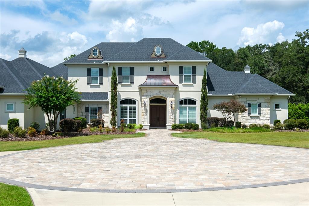 A perfect home to entertain family and friends. This executive custom built Tommy Waters home is situated on 5 acres in a gated community in NW Gainesville. From the moment you walk into the foyer you will appreciate all of the features that make this home unique. High ceilings, built in shelves and cabinetry, a game room with a wine cellar, wet bar area, and tongue and groove ceiling, a spacious flex room and sitting area upstairs, 4 car garage with an additional air conditioned storage room, 4 fireplaces and more. The seller just installed new ceiling fans and lighting fixtures, carpet in the study and wood flooring in the owners suite. When it comes to energy efficiency you will be impressed. The house has two high efficient HVAC units with multiple zones, spray foam insulation in the attic and a home generator. The pool area is spectacular and includes an oversized salt water pool and hot tub, travertine tiles, summer kitchen and bar area with a new grill. There is also a fire pit area for cooler evenings. You will enjoy all of the storage spaces including two closets in the owners suite with custom built closet systems, two pantries in the kitchen area, a media closet and walk in access to the attic with built-in decking. Call for a private tour of one of Gainesville best properties.
