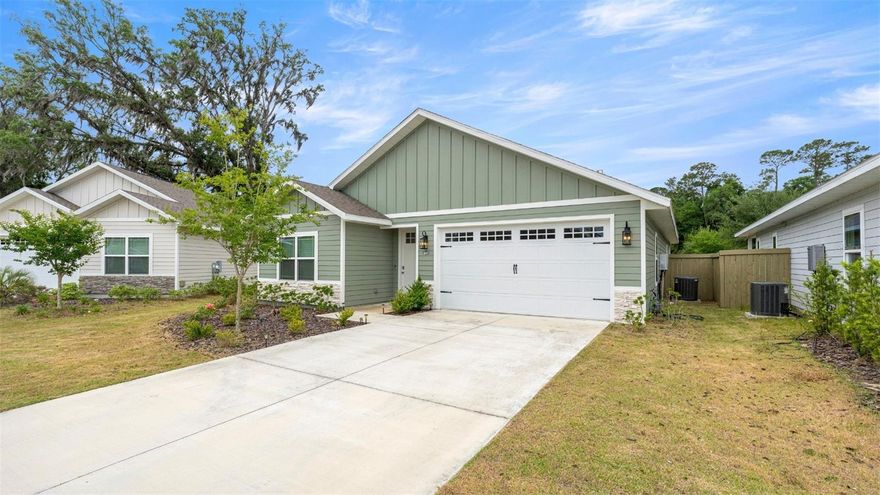 One or more photo(s) has been virtually staged. Welcome to this nearly new, thoughtfully designed, move-in-ready home In Grand Oaks that seamlessly blends modern luxury, and efficiency. Zoned for some of the best schools of Alachua county, it is located just minutes from the University of Florida, UF Health, Celebration Pointe, Day-care and premier shopping and dining. As you enter the home, the foyer takes you to an open living space where the family room, dining and kitchen create a seamless flow. The chef-inspired kitchen is designed to impress with quartz countertops, shaker-style soft-close cabinetry, a large center island with pendant lighting and seating, and an exceptionally spacious pantry—perfect for both everyday living and entertaining. The owner’s suite offers a private retreat with a tray ceiling, a generous walk-in closet, and French doors leading directly to the covered lanai. The spa-like en suite bathroom features a dual-sink quartz vanity and a zero-entry glass-enclosed shower with beautiful tile work. Two well-appointed guest bedrooms provide comfort and flexibility for family, guests, or a home office. A well-designed drop zone creates the perfect everyday landing space for backpacks, shoes, and keys.  Experience Florida living year-round with large covered patio, plus a fully fenced backyard ideal for pets, play, and outdoor entertaining. Designed with both comfort and sustainability in mind, the home features an energy-efficient solar system to help reduce utility costs, and a gas tankless water heater. The light-filled interior with 9-foot ceilings, tray ceilings, and crown molding create a sense of openness and architectural detail. Residents of Grand Oaks at Tower enjoy access to resort-style pool, cabana, playground, and scenic sidewalks.  Schedule your private tour today!