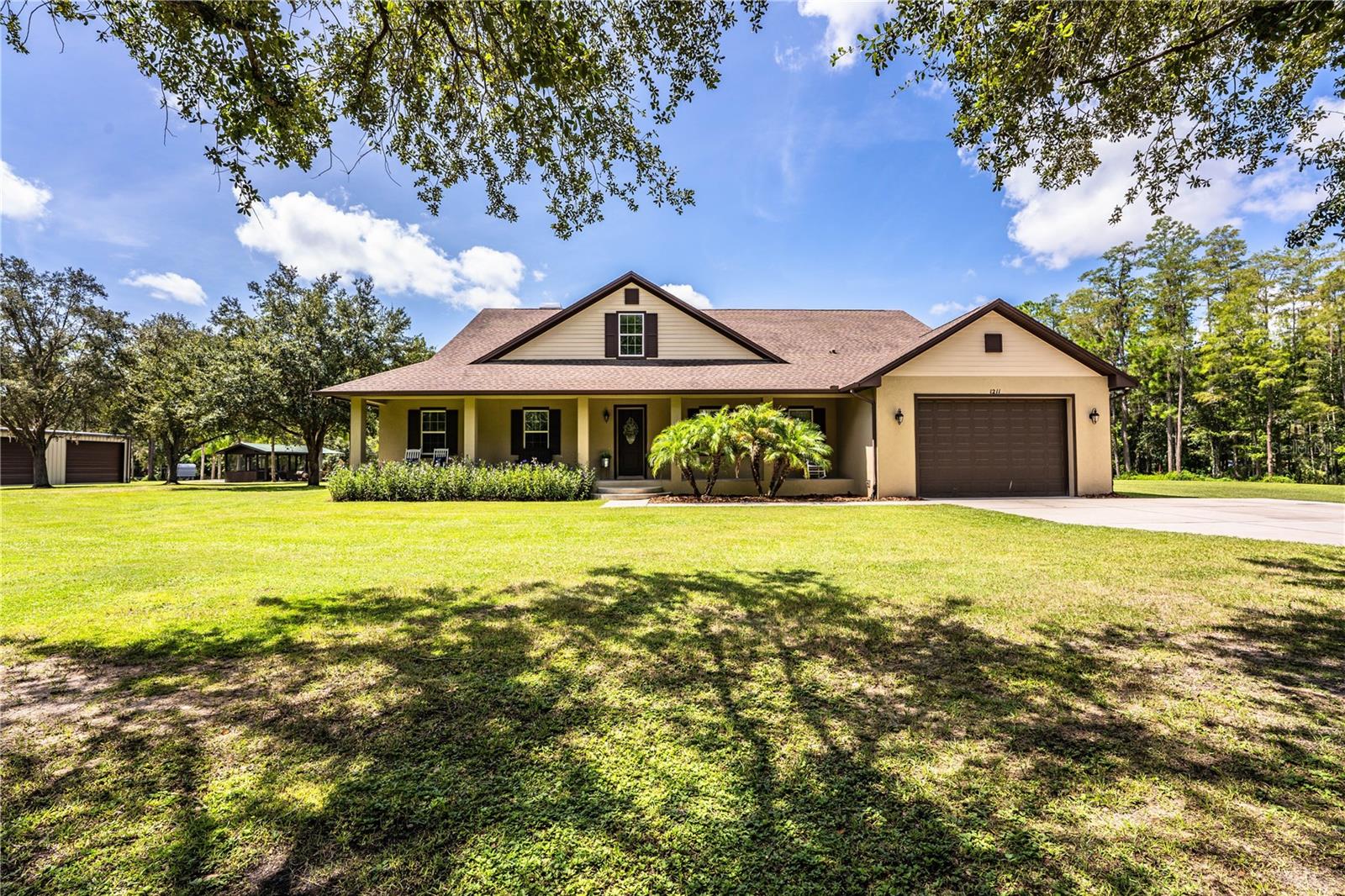 Spacious 4-Bedroom Home on 3.5+ Acres with Private Pond, Workshops & Outdoor Oasis! Built in 2017, this 4BR/2.5BA Davenport home blends modern comfort with serene country living. Inside, you’ll find granite countertops, modern appliances, crown molding, high ceilings, and a cozy wood-burning fireplace. The primary suite offers a soaking tub, walk-in shower, and large walk-in closet. Upstairs, fill any need with the generous bonus room of nearly 1,200 square feet! Enjoy Florida living year-round in the spacious screened lanai with outdoor kitchen overlooking your private pond. The pond features a covered, screened boathouse with electricity/water, deck for fishing, and a sandy beach area framed by palms. For hobbies or storage, you’ll love the 60x40 metal workshop with power, 4 bay doors, and gutters, plus a 30x30 block workshop with lean-to. The landscaped property offers open lawn, wooded views, and abundant wildlife. This home is set in Davenport: a small, rapidly growing community surrounded by quiet wooded expanses and rolling terrain typical of inland Florida. Imagine a peaceful country-like estate just outside Orlando, Florida’s tourism and entertainment capital. That means all of the big-city conveniences: shopping malls, golf resorts, fine dining, and world-class theme parks are nearby, yet you still get the serenity of rural living! Bring your toys and animals! With no HOA or CDD fees, this home provides endless possibilites and won't last long!
