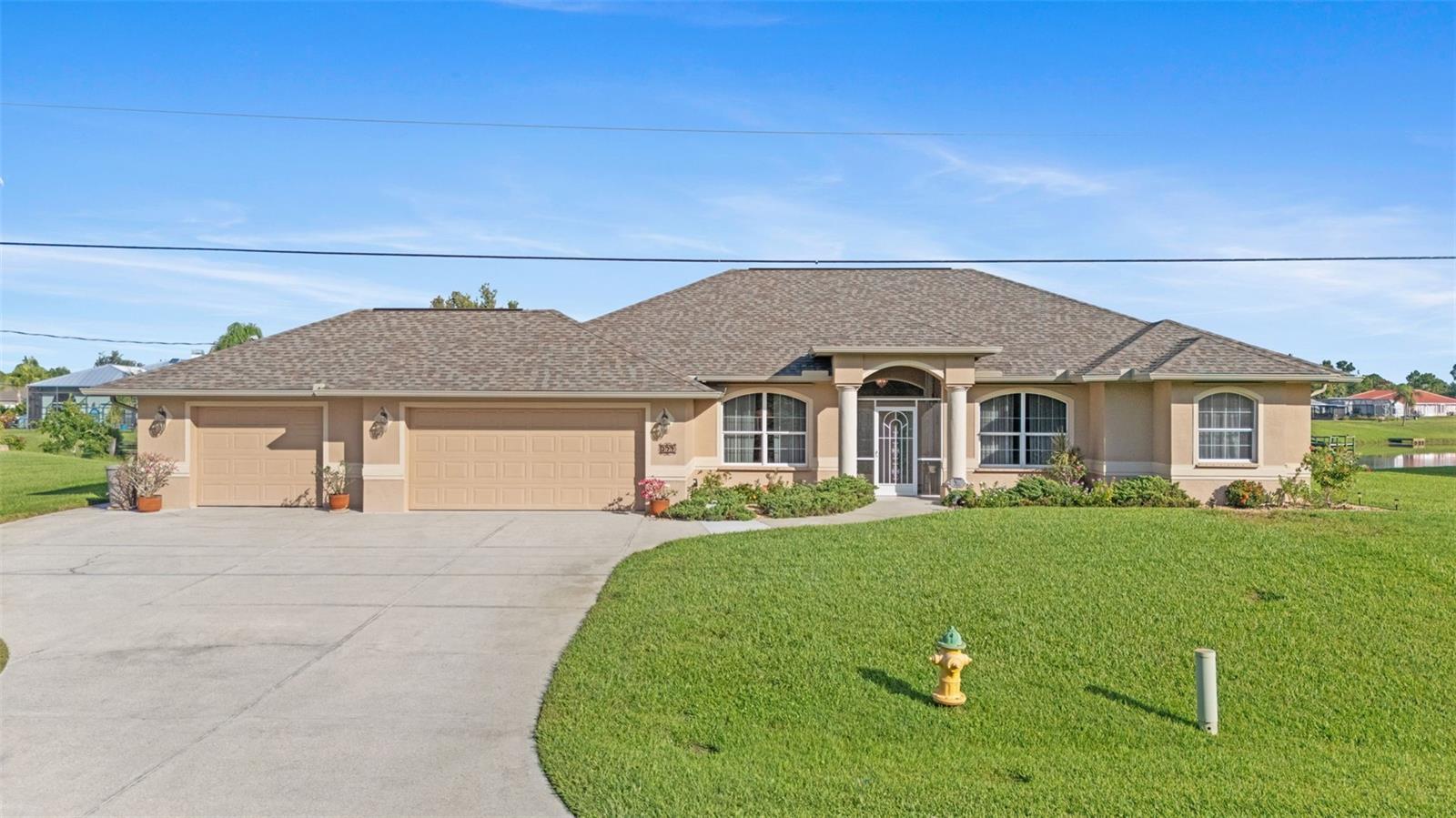 Step inside this beautiful, extremely well maintained, custom 3/2 lakeside home situated on 2 lots in Port Charlotte on a very low traffic street across from a designated green space park, several acres in size that will never have homes built on it. This home is a rare find and one that has everything that anyone could ever want in a home - and more. The owner was
a custom home builder and built this home to live in and spared no expense doing so. From the oversized 3 car garage/workshop, monitored security alarm system, intercom/audio system with speakers in most rooms, large walk in laundry room with storage galore and a mini refrigerator, heated in ground swimming pool, automatic propane powered whole house generator (in case of any power outage), accordion easy pull exterior storm shutters, granite counter tops, chefs kitchen with updated stainless appliances and a large walk in pantry, deluxe jacuzzi tub and walk in showers, new septic system, new roof, new pool
cage, an outdoor stove, large private bedrooms with a sitting area in the master, aquarium
glass view of the lake from the kitchen, large dining room and family room with built in storage, as well as a separate living room, tons of storage and closets throughout, large walk-in attic storage above the three garages- it even has a private office with etched glass doors. There are simply too many great features to list. This one has it all! Truly a one-of-a kind home and one that won't last long. Come see it today. It a spotless turn key move in ready home.