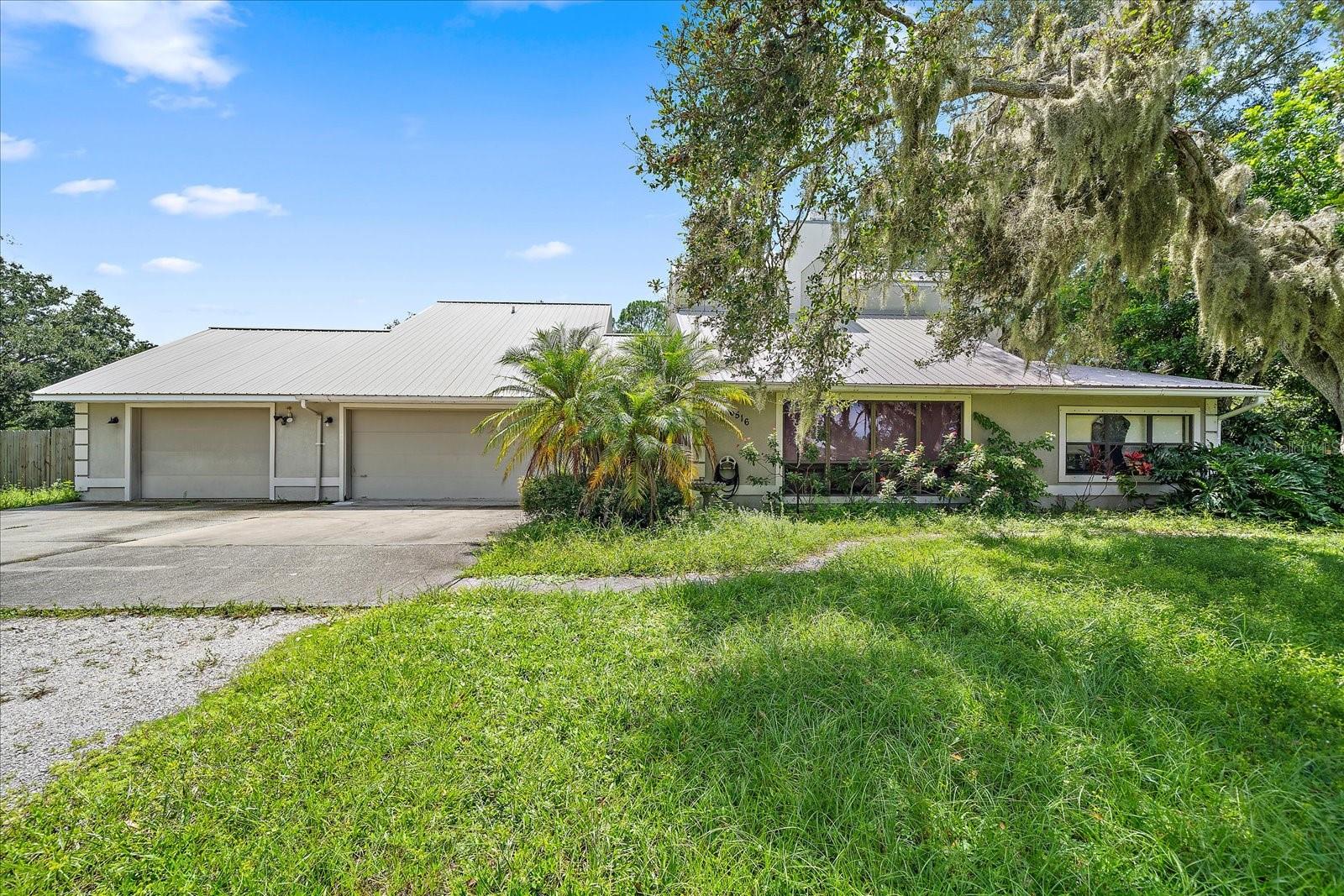 Welcome to 6516 Caracara, tucked away in the beautiful Lakewood neighborhood of Sarasota! This spacious residence sits on over one acre of land, set back from the road for privacy, and surrounded by serene landscaping with a peaceful pond. The property includes a versatile one-bedroom in-law apartment with a private entrance (and interior access if desired). It features a generous bedroom, living room, and kitchenette—ideal for guests, extended family, or rental potential. Offering more than 2,500 square feet of living area, the main home greets you with soaring vaulted ceilings and a cozy wood-burning fireplace in the living room. Updated wood plank tile floors run throughout, blending style with durability. The kitchen is a chef’s delight, with abundant cabinet and counter space, plus a sink framed by a large window overlooking the pool. An eat-in dining area and flexible floor plan allows room for a den or office. The primary suite includes a walk-in closet, en-suite bath with dual sinks, a large, jetted tub, separate shower, and French doors opening to the lanai. Additional highlights include a 3-car garage, Metal roof & block construction with No deed restrictions – bring your RV, boat, and toys! Not in a flood zone. With just a little TLC, this property can become your dream home. Enjoy the best of Sarasota living with easy access to I-75, world-class beaches, top-rated schools, shopping, dining, nightlife, and cultural attractions. Don’t miss the chance to make this unique property yours—schedule your showing today!
