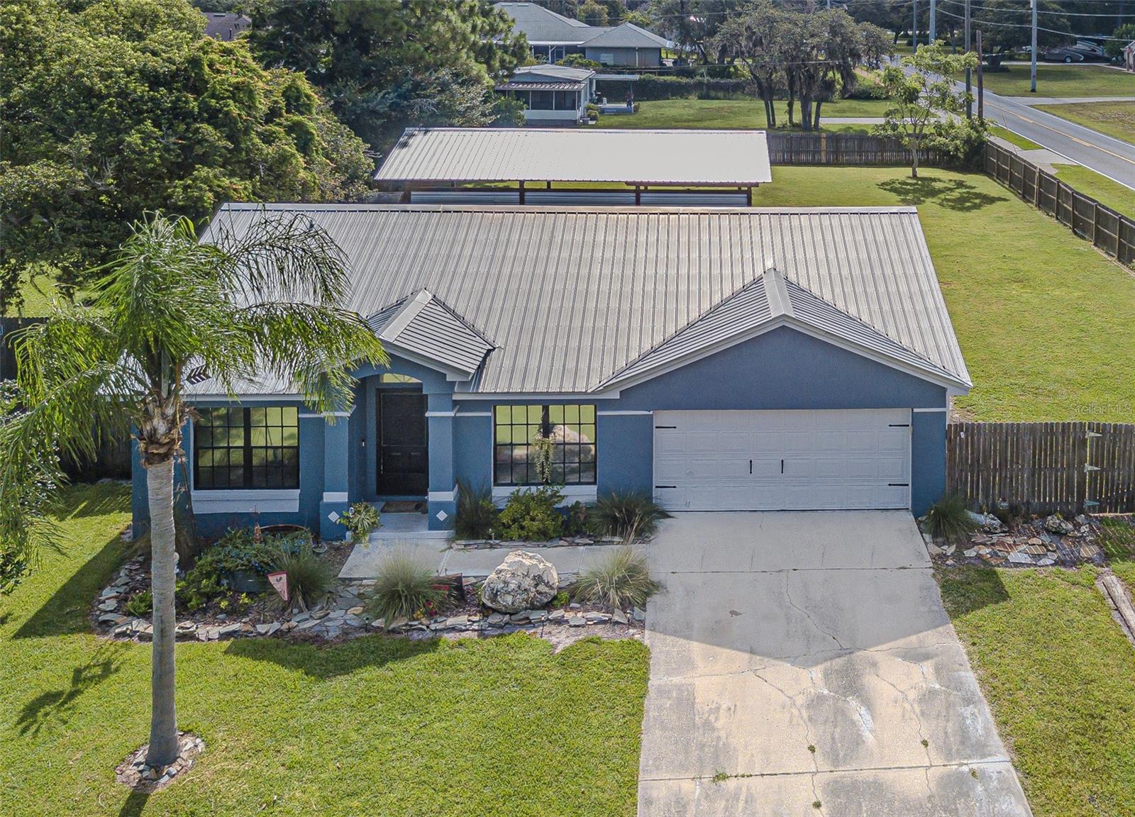 Welcome to this charming 3-bedroom, 2-bath home nestled in the heart of Lakeland, Florida. From the moment you step inside, you’ll appreciate the warm, rustic feel and spacious layout. The kitchen offers ample room and character, flowing seamlessly into the open living area with soaring ceilings that enhance the space and comfort. To the left of the entry, you’ll find two well-sized guest bedrooms and a full bathroom, ideal for family or guests. The private primary suite is tucked away off the living room and features a walk-in closet and a beautifully updated bathroom. Step outside to enjoy Florida living at its finest with a large screened-in lanai, perfect for relaxing or entertaining. The oversized backyard is fully fenced and includes a pole barn and a shed for extra storage or workspace. A spacious two-car garage completes the home, offering convenience and plenty of room for vehicles or tools. This one-of-a-kind property won’t last long, schedule your showing today!