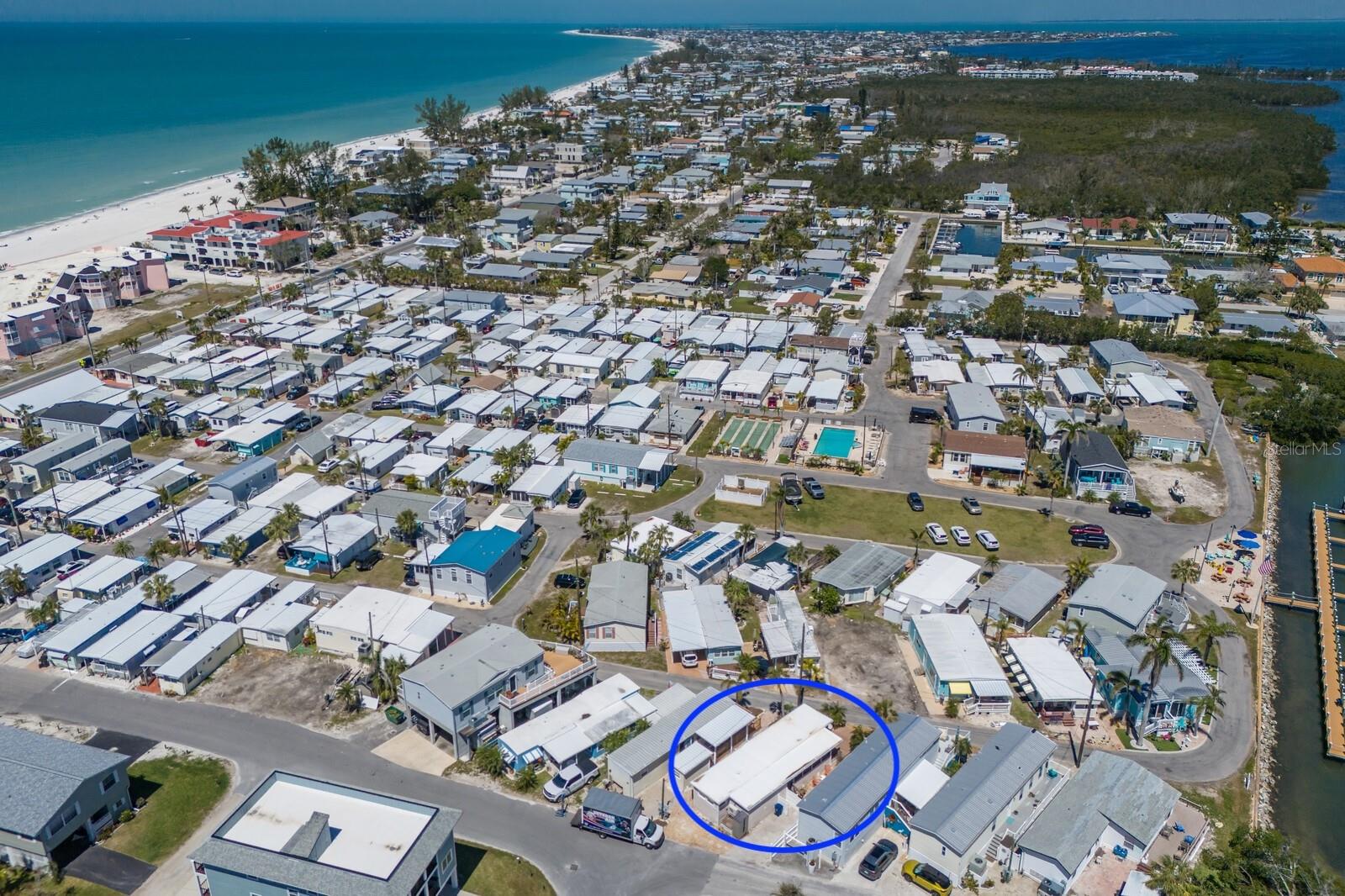 Welcome to Paradise! Sandpiper Resort Co-op is a vibrant 55+ community located on beautiful Anna Maria Island. This 2BD/1BA coastal retreat is on one of the larger lots in the community. Enjoy a day at the beach just steps away across the street or rest and relax in the heated community pool, play shuffleboard with friends, enjoy the clubhouse, fish or relax around the dock, or bring your boat to the 1st come slips! RECENT IMPROVEMENTS: full electrical inspection, 100 amp main breaker replaced and replaced all outlets and devices impacted by the hurricane, drywall replaced, new floors, paint, trim, bathroom vanity, 3 new mini split A/C units installed, and outdoor landscaping rocks replaced. This oasis is just waiting for your final touches in the kitchen, to suit your preferences. Great opportunity to have a freshly updated home to use now, included with one of the larger lots in the community that you could build a new elevated home on in the future if you choose to. Enjoy partial views of the intracoastal waters of the bay from the spacious front composite deck, use the hot/cold outdoor shower after days at the beach or fishing on the community dock, or the side patio offers a more private oasis for tranquil evenings. Don't miss out on an opportunity to enjoy Anna Maria Island at an affordable price, call for a showing today!