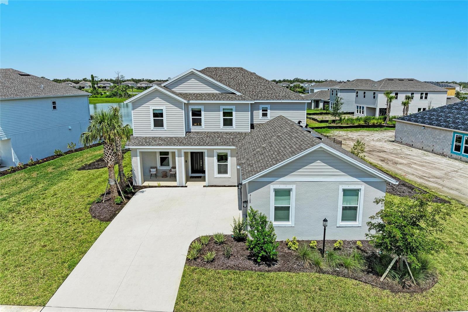 Embrace the ultimate in luxury living with this exquisite, nearly new Sand Key model, beautifully situated on a serene waterfront homesite in the exclusive, gated community of Skye Ranch. Why wait to build when you can move right into a nearly new designer-appointed residence offering just under 4,000 square feet of refined elegance and comfort?
This thoughtfully designed home boasts 5 spacious bedrooms, 4.5 bathrooms, a private home office, a grand bonus/game room, and a 3-car side-entry garage all perfectly tailored to elevate your lifestyle. From the moment you step inside, the soaring two-story foyer and sweeping staircase make a dramatic first impression, setting the stage for the elevated finishes and attention to detail found throughout the home.
Beyond the entry, French doors lead to a spacious office, ideal for those who value a stylish and private space to work or study. Formal dining and living areas and expansive open-concept family room seamlessly blend sophistication and functionality, all while offering unobstructed views of the tranquil lake.
At the heart of the home, the gourmet chef’s kitchen delivers both beauty and performance. Appointed with stainless steel appliances, a statement range hood, apron-front sink, walk-in pantry off the butler's pantry, quartz countertops, and an oversized center island, it was made for both entertaining and everyday luxury. The open layout flows naturally onto the covered lanai through sliding glass doors perfect for alfresco dining, sunset cocktails, or simply unwinding to the sounds of nature.
The main-floor primary suite is a true sanctuary, featuring a wall of windows overlooking the water, private lanai access, custom-designed closets, and a spa-inspired ensuite. With a frameless glass shower, dual vanities, and designer tilework, every element was crafted for relaxation and indulgence.
Upstairs, nearly 1,600 additional square feet offer a flexible second living space. Four generously sized bedrooms, two with ensuite bathrooms and one shared bath, each include walk-in closets, providing plenty of space for family and guests. The massive loft/bonus room serves as the ultimate entertainment zone, whether you envision a game room, home theater, or lounge space.
Luxury continues with plank flooring throughout the main living areas, designer tile selections in all bathrooms, an elegant powder room for guests, and a well-appointed laundry room.
Step outside and imagine the possibilities. The oversized backyard not only showcases breathtaking water views but also offers ample space to create your dream outdoor oasis where you can add a custom pool if desired.
Skye Ranch offers a lifestyle like no other. Tucked among preserved natural landscapes and scenic trails, this master-planned community features a resort-caliber amenity center with a sparkling pool, splash pad, clubhouse, fitness center, tennis and basketball courts, playgrounds, a climbing wall, café, and a brand-new K–12 school under construction. Located just minutes from Sarasota’s renowned dining, shopping, and cultural attractions and a short drive from world-famous Siesta Key Beach and Florida's top theme parks—this home delivers the perfect blend of serenity, style, and convenience.
Schedule your private tour today and step into the lifestyle you’ve been dreaming of.
