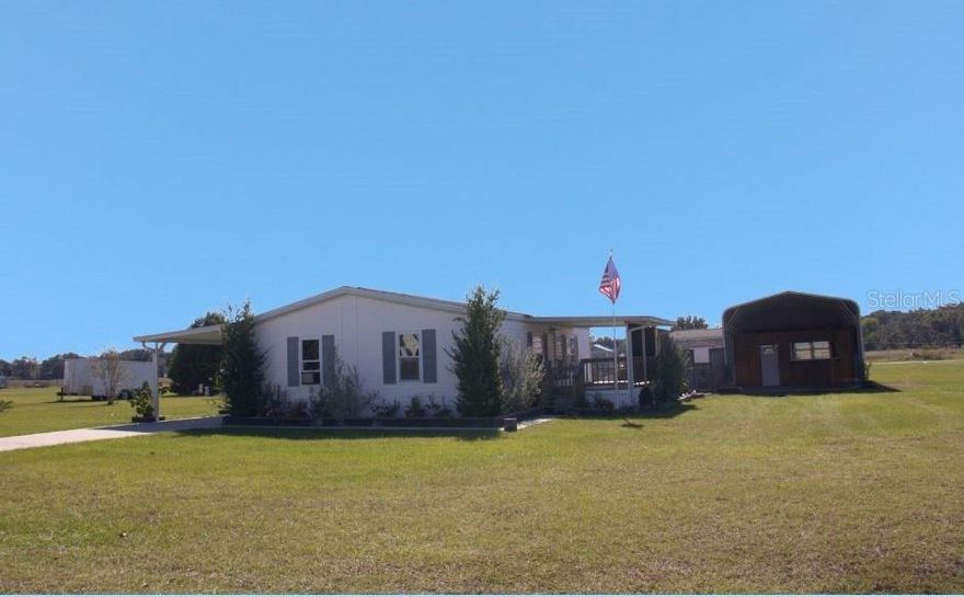 Welcome to Lake Panasoffkee, a popular destination town known for it's excellent fishing and water activities! This quaint community is where you will find this lovely, 2 bedroom, 2 bath double wide situated on an oversized .35 acre lot. The home interior offers an Open Living area with vaulted ceilings. The kitchen has newer appliances, closet pantry, breakfast bar and dining space. The split plan bedrooms with their own bathrooms means privacy for the whole family. The laundry room is conveniently located inside, too! Relaxing in your new home would be enough, but wait until you see what is waiting for you outdoors!! A covered front porch and private covered back deck with plenty of room for entertaining awaits. Then, step out into the garden oasis and gaze upon your own outdoor paradise. This huge property has been well maintained with tons of plants, trees and flowers in every corner. You will enjoy the gardens, 2 firepits, sitting areas and huge Gazebo, just for you! The 8' x 10' storage shed is great for storing all of your outdoor supplies. But wait, there's more! The 18' x 35' outbuilding/man cave features a workshop, more storage space and a covered concrete slab for your RV or other toys. Bring your boat!! Lake Panasoffkee is nearby. A true spring-fed lake, abundant with largemouth bass and panfish like bluegill and crappie. The home also offers a newer AC, a covered carport/driveway with plenty of parking, gutters with down spouts more. You will find small town living while still being close to everything! Just minutes to I-75, you are close to almost anywhere you need to go. Hurry! This home is priced right and will not last long!