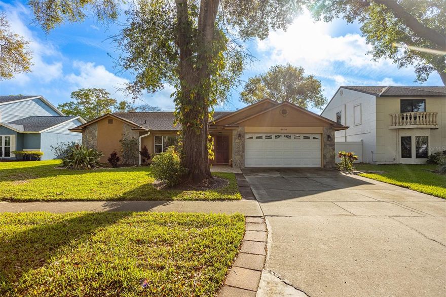 This charming home features a desirable split-bedroom layout in a quiet neighborhood in the heart of Tampa. Just minutes from the Carrollwood area, the property welcomes you with a spacious living and dining area highlighted by vaulted ceilings, expansive windows that fill the space with natural light, and durable ceramic tile flooring.

The kitchen had custom cabinets and a gas stove for the ultimate cooking experience! From your kitchen you are connected to the living and dining room in this open layout. This inviting space offers laminate flooring and a wood-burning fireplace, creating a warm, cozy atmosphere perfect for relaxing.

The primary suite is privately situated on one side of the home and includes a walk-in closet along with an en-suite bathroom featuring dual sinks and a walk-in shower. On the opposite side, you’ll find two additional bedrooms and a full hallway bath.

Sliding glass doors from the family room open to an oversized screened-in patio with tile flooring—ideal for entertaining guests or enjoying the outdoors. Just off the kitchen is a walk-in pantry with washer and dryer hookups for added convenience.

A fully fenced backyard completes this wonderful home, offering both privacy and space to enjoy.
