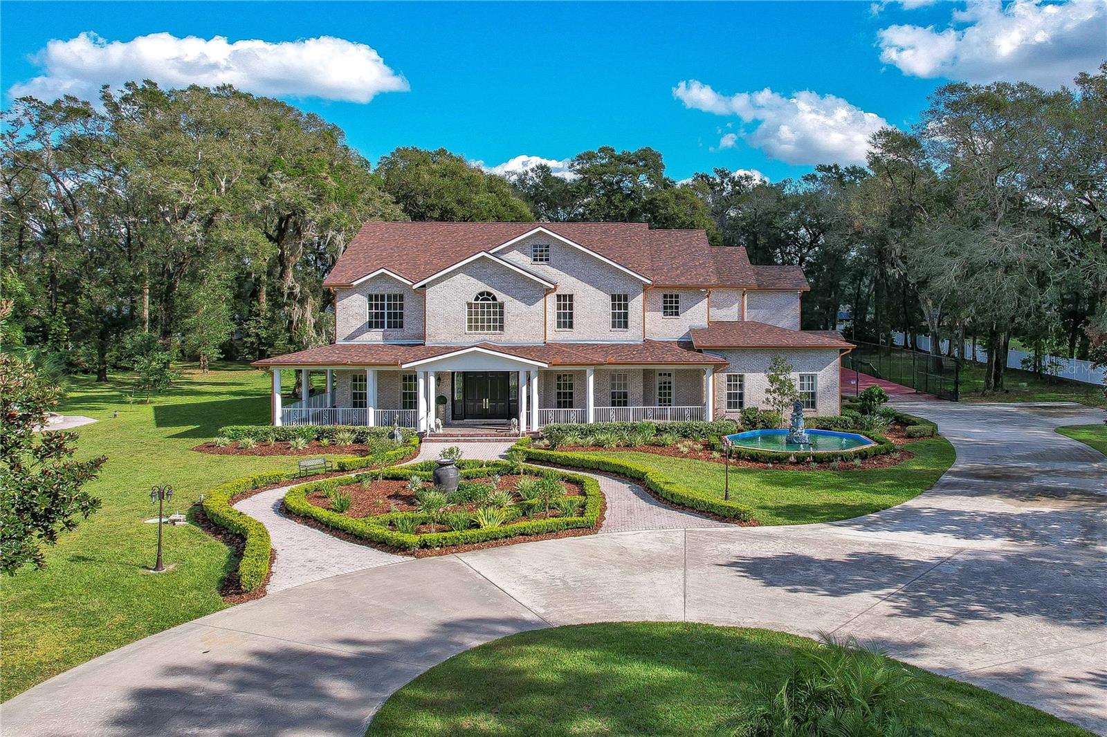 Extraordinary Home! This home is timeless and was built with everything that will make you feel at home and in decadent luxury at the same time. Over 5 gorgeous gated acres in a fabulous tree-lined street in a perfect location. Peaceful suburb in close proximity to Tampa and still less than an hour to Disney and the beaches. This dream home awaits with beautiful JC FOWKE construction. Premier builder offers Brick exterior over block construction for energy efficiency and beauty! There is a NEW ROOF installed in 2021 so you have this big ticket item already taken care of! Double front doors lead to 2 story breathtaking foyer with grand staircase. Gorgeous dining, plantation shutters, and fabulous oversized stunning floors throughout. Bring the yardstick to measure the molding both for base and crown molding, it is crazy fantastic…and it’s everywhere! This house flows effortlessly, with no wasted space, perfect living with built-ins, fireplaces, and all the luxuries that make it fantastic, but a functional warmth where you and your family could live and have the memories that showcase a lifetime of love. This home is equipped with an elevator that takes you anywhere from the first floor all the way up to the third floor where there is a large bonus room! There is a side entry that leads to a huge private office. Work from home, run your practice from home, you decide. Huge laundry with outdoor access just off the kitchen along with half bath. Kitchen is spacious with lots of light with room for cozy moments with your favorite people. High-end appliances and all the goodies you expect and love! Six… yes SIX car garage with oversized doors and high ceilings and just outside is a sport court for basketball, tennis, or pickleball! The party will always be here! The pool is worthy of a resort at Disney with a slide, beach walk-in entry, and a huge space for entertaining. Great views from everywhere and so well matched for this gorgeous showcase home! Grab your pool float and relax around this lazy river-style 75,000-gallon pool or splash down the water slide for some lively fun! The travertine pool deck was refinished with a water-repellent sealer and the entire pool surface was refinished in 2022! This home has 5 bedrooms, every bedroom has a private bath; a guest house with private kitchen, bath, and bedroom; and three half baths. If 5 bedrooms plus a guest house isn’t enough for you, also included is a Murphy bed. The guest house features a private entry and secret passage if needed. Master is stunning with private sitting area and a fireplace, as well as an incredible luxury master bath with an upgraded walk-in shower and private balcony. You will certainly fall in love with the amazing media room/bonus. Huge bedrooms for all and up-and-down laundry areas serve the house beautifully. The entire property is irrigated by a well which will mean low water bills! Wrap around front porch, fountains, incredible location, acreage and so much more that we could talk about forever or you can come and see for yourself and buy your forever home. Zoning is ASC-1 so allows for up to 3 more homes on the land with no variance! It is the loveliest of them all and the setting is magical. Don’t miss this unique opportunity to own a dream oasis!