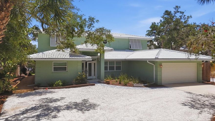 Set along an exclusive, banyan-lined enclave of Manasota Key, this exceptional bayfront residence offers a rare blend of privacy, refinement, and effortless coastal living. With approximately 120 feet of direct frontage on Lemon Bay and a deeded 6-foot beach access just across the street, the property delivers an enviable bay-to-Gulf lifestyle in one of Florida’s last unspoiled barrier island settings. A comprehensive series of recent upgrades—including a new tile roof (2023), dual A/C systems (2024), new septic and water lines (2025), new sod and landscaping (April 2026), and impact-resistant windows & protection with electric hurricane shutters—ensures a turnkey experience defined by both sophistication and peace of mind.  Inside, the light-filled interior reflects a relaxed yet sophisticated coastal aesthetic, highlighted by a completely remodeled kitchen (2025) with 42” soft-close cabinetry, granite countertops, decorative backsplash, and stainless appliances. The flexible floor plan offers a first-level primary suite—currently utilized as a home office—along with guest accommodations, while the second level is dedicated to two private master suites with walk-in closets and a shared sitting area, creating an ideal retreat for family or guests. Expansive living spaces transition seamlessly outdoors to a full-length screened lanai with new composite decking, where tranquil bay views, passing boats, and abundant wildlife create a constantly evolving backdrop. An additional paver patio offers the perfect setting to create your own firepit retreat, inviting cozy evenings under the stars. This freshly landscaped residence also features a circular drive, shared dock, and outdoor shower, completing this private waterfront sanctuary.  Perfectly positioned for both seclusion and convenience, this remarkable property offers close proximity to waterfront dining, marinas, golf, and the cultural offerings of nearby Englewood, Venice, and Sarasota—while remaining a peaceful retreat defined by natural beauty, quiet surroundings, and direct access to the best of Southwest Florida coastal living.