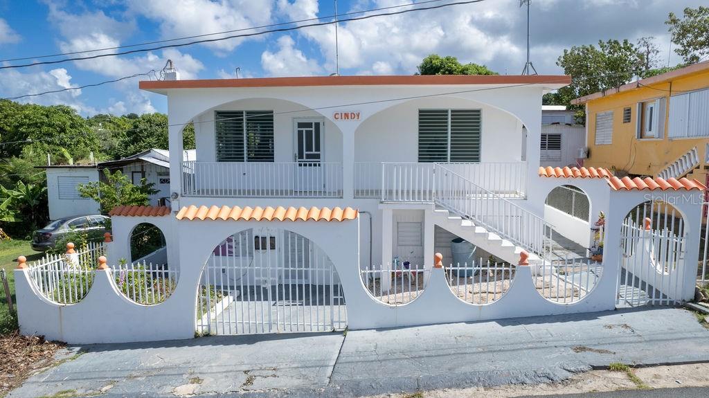 Casa Cindy is a well-positioned home in the elevated area of La Esperanza, offering incredible views of the Caribbean Sea and refreshing trade winds. This south-facing property is split into two separate apartments, each with its own private entrance and direct access to a spacious, quiet rear patio, ensuring privacy and convenience.
The second-floor front balcony opens into a bright and expansive living area with high vaulted ceilings, allowing for abundant natural light. The open-concept kitchen blends seamlessly with the living space, offering both practicality and style. Three generously sized bedrooms provide ample room for king-sized beds and armoires, making it the perfect place to rest after a day at the beach or a night out.
The lower level is currently used as a salon space, but can easily be converted back into second unit. Complete with three bedrooms, one bathroom and kitchen with large living area, and AC, this unit can continue to be leased as a commercial space or easily be remodeled into a comfortable space for guests or an income producing rental.
The large backyard offers multiple possibilities for outdoor living, whether it’s building a pool, setting up an outdoor kitchen and BBQ for entertaining, or creating a serene space to relax. This peaceful patio is an ideal spot for reading, writing, or simply enjoying the quiet surroundings.
Whether you're enjoying the spacious living areas, taking in the sea views, or unwinding in the peaceful backyard, this home provides the ideal setting for relaxation. With its versatile layout and prime location in La Esperanza, it’s a true haven for anyone seeking a convenient lifestyle and proximity to restaurants, shops and beaches of Esperanza.