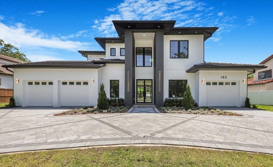 Welcome to a stunning new home positioned near Windsong and the AdventHealth Hospital. This extraordinary property boasts 4,812 square feet under AC. The stately manner is thoughtfully designed with four commodious bedrooms and five full-size bathrooms. Additionally, it features an expansive three-car garage complemented by an impressively constructed circular paver driveway. 
The first floor showcases lofty 11.4-foot ceilings, while the second floor features equally impressive 10-foot ceilings. A plentiful array of windows and numerous sliding doors augment the home's overall charm by inviting a flood of natural sunlight. A medley of Lutron dimmers and smart switches grants effortless convenience at your fingertips.
You will be warmly welcomed by a majestic steel glass hurricane impact door. Upon setting foot into this marvelous residence, one is instantly greeted by the glow of Oak wood floors, thoughtfully woven throughout each corner of the abode. Well-appointed Walnut and Oak wall panels add an unparalleled layer of understated luxury to this remarkable home.
The kitchen is a visual treat with an expansive waterfall island dominating the space. Floor-to-ceiling cabinets deliver abundant storage while the gleaming Quartz countertops exhibit both beauty and durability. To add to its grandeur, a matching Quartz backsplash extends all the way to touch the ceiling, seamlessly melding simplicity with luxury.
The kitchen comes fully equipped with all Thermador appliances, ready to cater to your every culinary need. This suite of top-tier appliances includes a grand 72-inch combo Freezer/Wine Tower/Fridge, a natural gas 48-inch Range with a steam oven guarantees an enjoyable cooking experience each time. Two fully equipped laundry rooms, one located on each floor.  The master bedroom features an expansive sliding glass door leading you directly to the tranquillity of the sprawling backyard.
The master bathroom is a serene, spa-like haven designed with luxurious Italian tiles, a natural stone accent wall that lends an air of sophistication. The floating cabinets add to the modern aesthetic and are enhanced by the backlit marble countertops, radiating a soft glow, adding to the relaxing atmosphere.
The second floor boasts 3 well-appointed bedrooms and corresponding bathrooms, each outfitted with Marble countertops that enhance their plush ambience. Uniquely offering versatility, a large flex area graces this floor, which could be customized according to your liking or needs. Ensuring fun entertainment spaces within the confines of your home exists a game room too, catering to all age groups! The special feature is an in-built wet bar complemented by Cristallo Quartzite counters and custom cabinetry, thus serving as an ideal indoor party venue. As an extension of indoor living space, the outdoors is a sizeable terrace accented with contemporary glass railings.
Yes, the backyard is a true oasis in this property. A large covered lanai provides ample space for relaxation or outdoor dining. The summer kitchen features state-of-the-art appliances to assist in making your entertaining dreams come true. No luxury home would be complete without a pool, and this one comes with a gas-heated saltwater pool and a spa. A full pool Bathroom with a Steam Shower. Travertine pavers enhance the overall appeal.
In conclusion, the home exhibits a smooth blend of advanced technology and high-end finishes, promising a luxurious living experience!