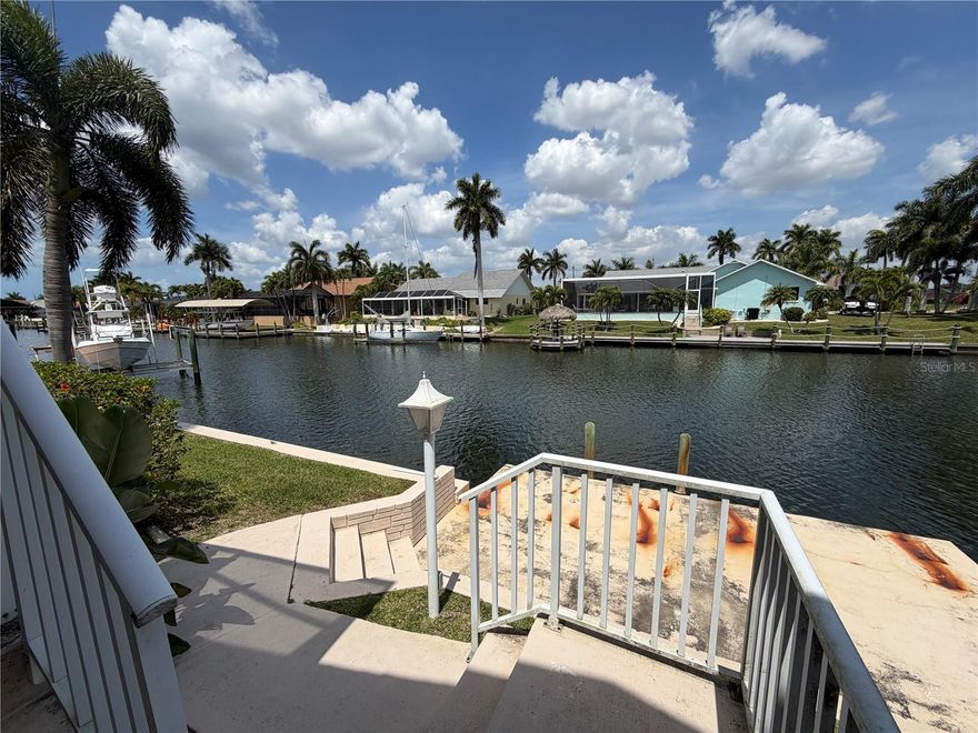 DIRECT GULF ACCESS, MINUTES TO OPEN WATER, POOL HOME, AND WALKING DISTANCE TO CAPE HARBOUR Welcome to your slice of waterfront paradise with NO BRIDGES and direct Gulf access, perfectly positioned on a wide canal and just minutes by boat to open water. This prime location offers the best of both worlds with a short walk to Cape Harbour’s dining, shopping, and marina lifestyle, as well as nearby grocery stores, restaurants, and everyday conveniences. This custom built, one owner home offers 2,674 square feet under air with 3 bedrooms, 2 bathrooms plus a separate pool bath, offering both space and functionality . A circular driveway, lush white rock landscaping, and double entry French doors create a stunning first impression. Inside, you will find soaring and vaulted ceilings, tile flooring throughout, and an open, light filled layout featuring two spacious living areas, a real stone wood burning fireplace, and two dining spaces perfect for hosting or creating a cozy breakfast nook. The updated kitchen showcases quartz and granite style countertops, white appliances, an extra large refrigerator and freezer, electric KitchenAid cooktop, and double wall ovens, making it ideal for everyday living and entertaining. The primary suite is a private retreat with sliding doors to the lanai, two walk in closets, and a spa like bathroom featuring dual sinks, a makeup vanity, oversized shower, and a jetted soaking tub. Function meets convenience with a huge laundry room complete with quartz countertops, upper and lower cabinetry, backsplash, sink, and newer Whirlpool washer and dryer. The finished garage includes built in cabinets and workbenches for additional storage and functionality. Designed for true indoor outdoor living, pocket sliding glass doors open the home completely to the covered lanai, where you will find electric fabric shutters, a newly installed pool enclosure, a pebble finished patio, outdoor shower, and a dedicated pool bath for seamless entertaining. Additional upgrades include a newer roof completed in 2023, updated two zone AC systems, fresh interior paint, updated guest bathroom, and new carpet in guest bedrooms. The home is fully equipped with extensive hurricane protection including shutters and accordion panels for added peace of mind. With no history of flooding, a concrete cantilever dock already in place, and space to design your ideal lift or boating setup, this property is truly a boater’s dream and a rare opportunity to create your ideal waterfront lifestyle in one of Southwest Cape Coral’s most desirable locations.