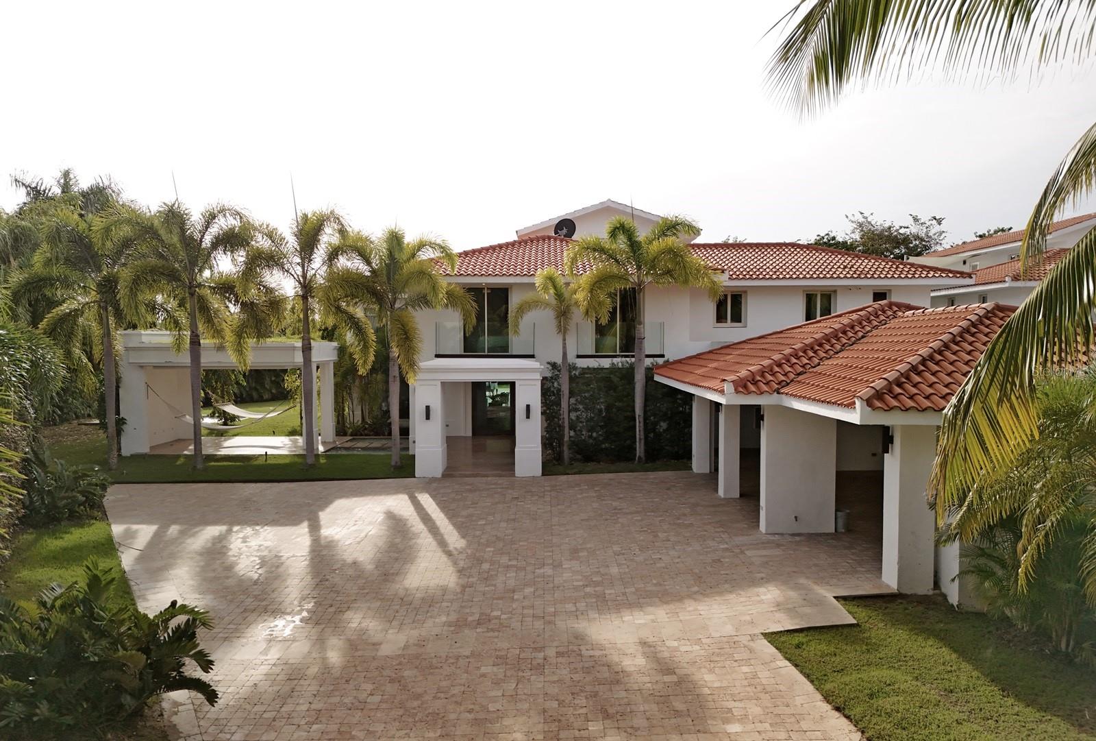 Discover your dream home in the heart of paradise! This stunning, sun-drenched 6-bedroom, 7.5-bathroom property spans over 8,704 sq. ft. and is nestled in the midst of a lush, tropical community. With its open and contemporary design, cathedral ceilings, and elegant tiled floors, this home exudes luxury. The gourmet kitchen is a chef's delight, equipped with high-end appliances, while the expansive pool is the perfect place to unwind and entertain. Plus, you'll have peace of mind with a gas power generator and a water cistern to keep you comfortable in any situation.
Located within the Dorado Beach Resort, since it is a 2,000-acre natural reserve most of the communities are 1-3 miles away from the beach and Hotel. This being said, the entire resort is interconnected via golf cart trails, meaning that you can have easy access (walking or in golf cart) to the different communities and amenities within this Resort. Owner is open to rent at $40,000 monthly.