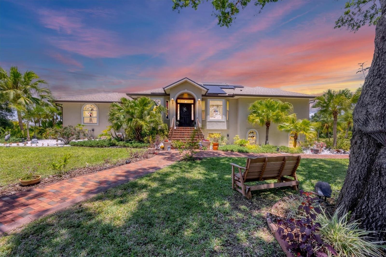Elegant Custom Estate on Over 4 Acres with In-Law Suite – No Flood Insurance Required! Welcome to your private retreat just minutes from town! This stunning 4-bedroom + den, 3.5-bath custom home with a 3-car garage sits on over 4 acres of serene, agriculturally zoned land that is ideal for horses, farm animals, or simply embracing a peaceful country lifestyle. Step inside to soaring ceilings, rich Bolivian Rosewood flooring, and an open-concept layout that blends everyday comfort with timeless elegance. The main living area features oversized sliding pocket doors that open fully to a screened Trex deck, creating seamless indoor-outdoor living, perfect for entertaining. The thoughtfully designed kitchen combines form and function with Cherrywood cabinetry, granite countertops, a tile backsplash, stainless steel appliances, a counter-height breakfast bar, and a sunny breakfast nook overlooking tranquil pond views. A separate family room and formal dining room add to the home's versatility, while a dedicated office makes working from home a breeze. A split-bedroom layout offers privacy for everyone. The guest wing includes two bedrooms, a full bath plus a 1/2 bath with stackable washer/dryer, along with generous closet space. The expansive primary suite, with private lanai access offers two closets—including a large walk-in—and a spa-inspired bathroom featuring granite counters, dual sinks, custom cabinetry, a jetted soaking tub, and a beautifully tiled walk-in shower. One of the home’s most unique features is the approx. 2,000 SQFT in-law suite, providing outstanding flexibility for multigenerational living, guest accommodations, or rental income. With its own private entrance and interior access, it includes a spacious living/dining area, oversized bedroom, full bath, kitchenette, wood plank style tile flooring throughout, a large laundry room, and its own mini-split A/C system. Enjoy outdoor living at its finest with your choice of spaces, from the upper screened lanai to the open-air lower deck that features a hot tub! The perfect space for watching fish jump in your private pond, taking in the peaceful surroundings, or stargazing at night. This country estate is loaded with upgrades, including a new roof, gutters, and upgraded enclosure screens (2022), Hurricane-rated garage doors with epoxy flooring, new flooring in guest bedrooms, whole-home solar energy system, dual HVAC systems and 18” attic insulation, whole-house reverse osmosis water system, dual water heaters (solar and hybrid), central vacuum and invisible pet fencing, well-fed irrigation system and backyard shed, tropical landscaping with landscape lighting, RV parking with hookup, plus a portable Generac generator is included (not currently connected). Best of all, this home is not located in a flood zone—flood insurance is not required, offering peace of mind and additional savings. Agricultural zoning allows you to fully enjoy a rural lifestyle. Bring your horses, plant a garden, or raise animals while still being just minutes from I-75, Gulf beaches, shopping, dining, and parks. This exceptional property offers elegance, space, and versatility, a rare opportunity that won’t last. Schedule your private showing today and see everything this one-of-a-kind estate has to offer!