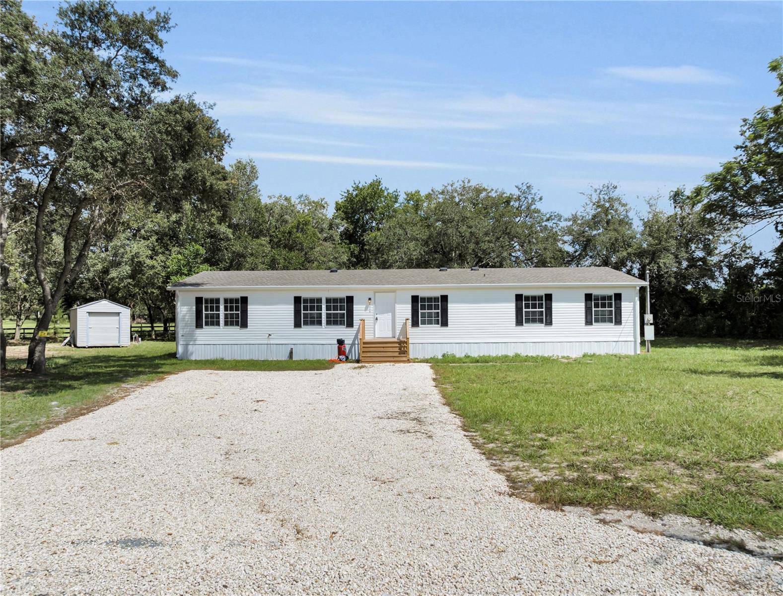 Turn-key and fully remodeled, this stunning 2003 Jacobson home offers six bedrooms, three baths, and 2,108 square feet of air-conditioned living space. Set on a secluded 0.51-acre lot at the end of a quiet cul-de-sac with only single-family residences nearby. The layout features a split floor plan with two master suites—perfect for multi generational living or guest. The primary owner's suite includes a double vanity, tiled shower, walk-in closet, and pantry, while the second master boasts a brand-new vanity and tiled shower. Inside, you'll find taped and textured walls freshly painted in Killm Beige satin, complemented by waterproof 7MM laminate flooring throughout—no carpet in sight. Every light fixture, fan, door, trim, and toilet has been replaced with sleek, modern finishes. The spacious living and dining rooms flow into a completely remodeled chef’s kitchen, featuring white shaker cabinets, Arctic Ice quartz countertops, and a brand-new smudge-proof Frigidaire appliance package with a one-year manufacturer’s warranty. 5-ton energy-efficient Rheem AC unit installed in August 2021, still under parts warranty. A brand-new 30-year dimensional shingle roof with new gutters ensures peace of mind, and the home also includes a new sliding glass door and all-new stairways. Structural updates under the home include new insulation, a moisture barrier, and hurricane strapping, all up to code. The well tank is newly installed, and the septic system has been serviced and emptied. For extra storage, there's a 10x20 aluminum shed. With county property to one side and a sprawling 20-acre estate to the other, this location offers unmatched privacy. The titles to the manufactured home have been retired, making this remarkable property eligible for traditional financing. Quite simply, it's one of the nicest homes currently available in Citrus County.