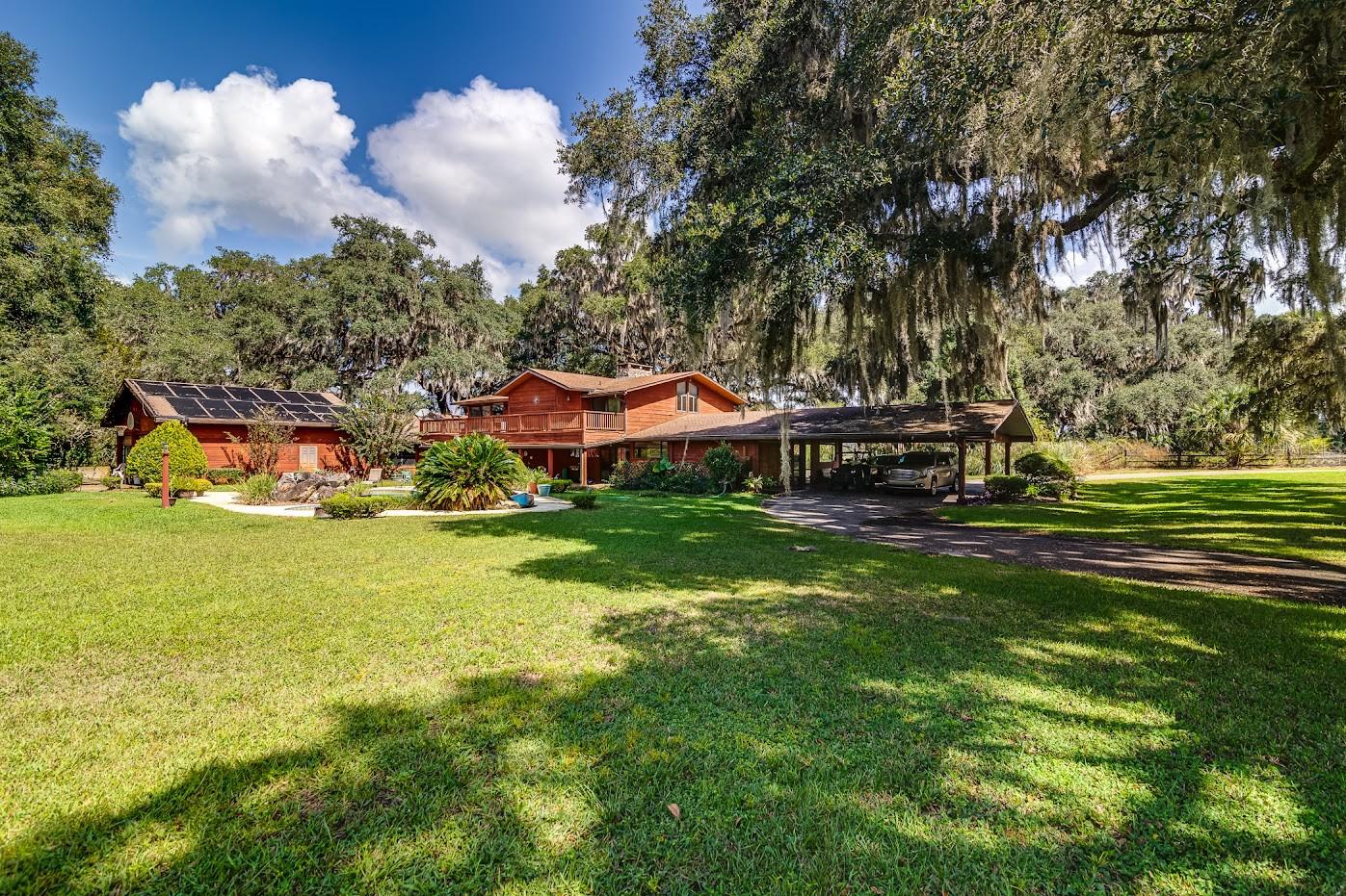 Welcome to "Lazy J Ranch". Please click on Link to see a video tour. Comprised of 320 acres balanced between Lush Vibrant Pasture, Enchanting Oak Hammocks, Picturesque Hay Fields and 4 Large Spring Fed Ponds. This very private cattle farm has vistas reminiscent of the Serengeti. It is located on a paved county maintained road in rural Levy County (LOW property taxes), Just a few minutes from Shopping & Dining in the quaint town of Williston. Gainesville is a short 20 minute drive where there are Stellar Medical services, University of Florida ,Dining, shopping and an airport. The main home ( 5496 sf under air) is constructed of Cedar / Pecky Cypress & Knotty pine construction. 3 bedroom, 2.5 bath, Open floor plan with Cathedral Ceilings, soaring Rock Fireplaces, Billiard room, office, conference room, wet bar, porches, decks, swimming pool and a 3 car garage as well as a 4 car portico. There is a wall of Sliders that open to a deck overlooking one of the 4 Spring fed Ponds.The kitchen is spacious with an island sink and breakfast bar. Currently, the Master bedroom is upstairs with a living area and 2 sets of sliders that lead to the deck overlooking the swimming pool. There is plenty of room downstairs to create another master bedroom if desired. Built in 2002, the Lodge style guest house is adorable. Light and bright with an Open floor plan. 2 bedrooms and 2 baths,lots of closets, A Fireplace and huge deck overlooking "House Pond". The home on this property sits back 8/10ths of a mile on a paved driveway creating a very private setting.Wildlife abounds....enjoy nature at its best. If you ride Horses , this is a trail riders dream with plenty of flat places for a ring if desired. Ranching? the Grass is lush for raising livestock. Fisherman? Trophy Bass have been caught in these ponds. Developing? Levy county currently has this zoned for the possibility of creating 10 acre parcels. With so many opportunities, come take a look . You won't be disappointed. New Roof on the main house in 2016, pool pump 2022, filter system 2023. Septic pumped 2021. Guest house septic pumped 2019. HVAC units serviced and in good working condition. Termite Bond in place. Several RV campsites.