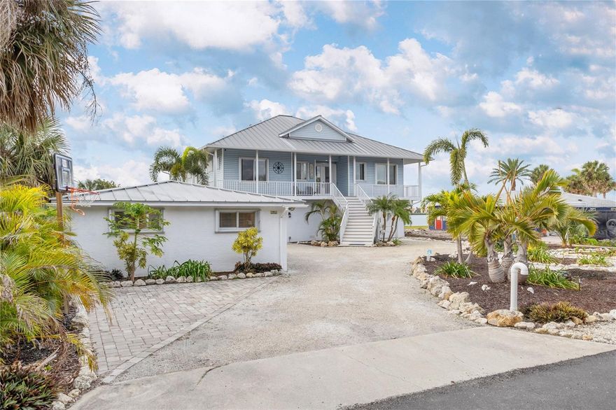 Welcome to your private waterfront sanctuary in a sheltered cove just off of Lemon Bay—an extraordinary custom-built Key West-style residence with breathtaking views. Perfectly positioned to capture the beauty of Southwest Florida, this home offers the ultimate blend of serenity, comfort, safety, and elevated coastal living in a sheltered bay with very low boat traffic. 
From the moment you arrive, you’ll be captivated by the home’s breezy island ambiance, where light-filled interiors and thoughtful design create a seamless flow for everyday living and elegant entertaining. Step through the double entry doors into an inviting space featuring soaring 10-foot ceilings, timeless coastal finishes, and an open-concept layout designed to showcase the water views. The spacious great room and kitchen offer granite countertops, updated custom Kraft Maid cabinetry, and effortless sightlines to the sparkling water beyond. A versatile bonus den/third bedroom provides ideal flexibility for guests or a home office.
Step outside to experience your own backyard oasis featuring an enclosed, heated saltwater pool (2022) surrounded by lush tropical landscaping, a natural-scape waterfall with grotto seating, along with a fire pit and multiple areas to lounge or dine—perfect for embracing the indoor-outdoor lifestyle Florida is famous for.
For boating and water enthusiasts, enjoy direct access to the bay (navigable in high or low tide) for sunset cruises or fishing. The property also features a newer seawall (2021) and a lower boat launch for paddle boards and kayaks for more unforgettable days on the water. A brand new composite dock and 10,000 lb boat lift (2025) are ready for use and relaxing.
This property is as functional as it is beautiful, featuring two tandem garages with space for up to four vehicles, plus additional storage for beach toys and watercraft. Bonus rooms add extra space for hobbies, fitness, or workshop needs. The beautifully remodeled detached building provides a charming guest house/art studio/mother-in-law suite complete with a full bath and small kitchen—ideal for multigenerational living, visitors, or rental potential.
Move-in ready and extensively upgraded with over $200,000 in renovations, this home also delivers exceptional peace of mind. Built in 2001 by a highly reputable builder under newer Florida building codes, it sits approximately 14 feet above sea level and successfully weathered recent hurricanes. The home is supported by deep-set concrete pilings engineered to withstand up to 10 feet of soil erosion, providing added confidence for coastal living. Additional highlights include easy to use accordion hurricane shutters and a seamless metal roof.  Just minutes to the beach, local restaurants, shopping, golfing, biking trails, beach yoga, and the Thursday farmers market on historic Dearborn Street—this is a lifestyle of ease, beauty, and effortless luxury.
Thinking investment? This property currently rents at $7,000 per week. Whether you’re seeking a full-time waterfront residence, a second-home retreat, or an income-producing coastal getaway—this one is truly unforgettable.