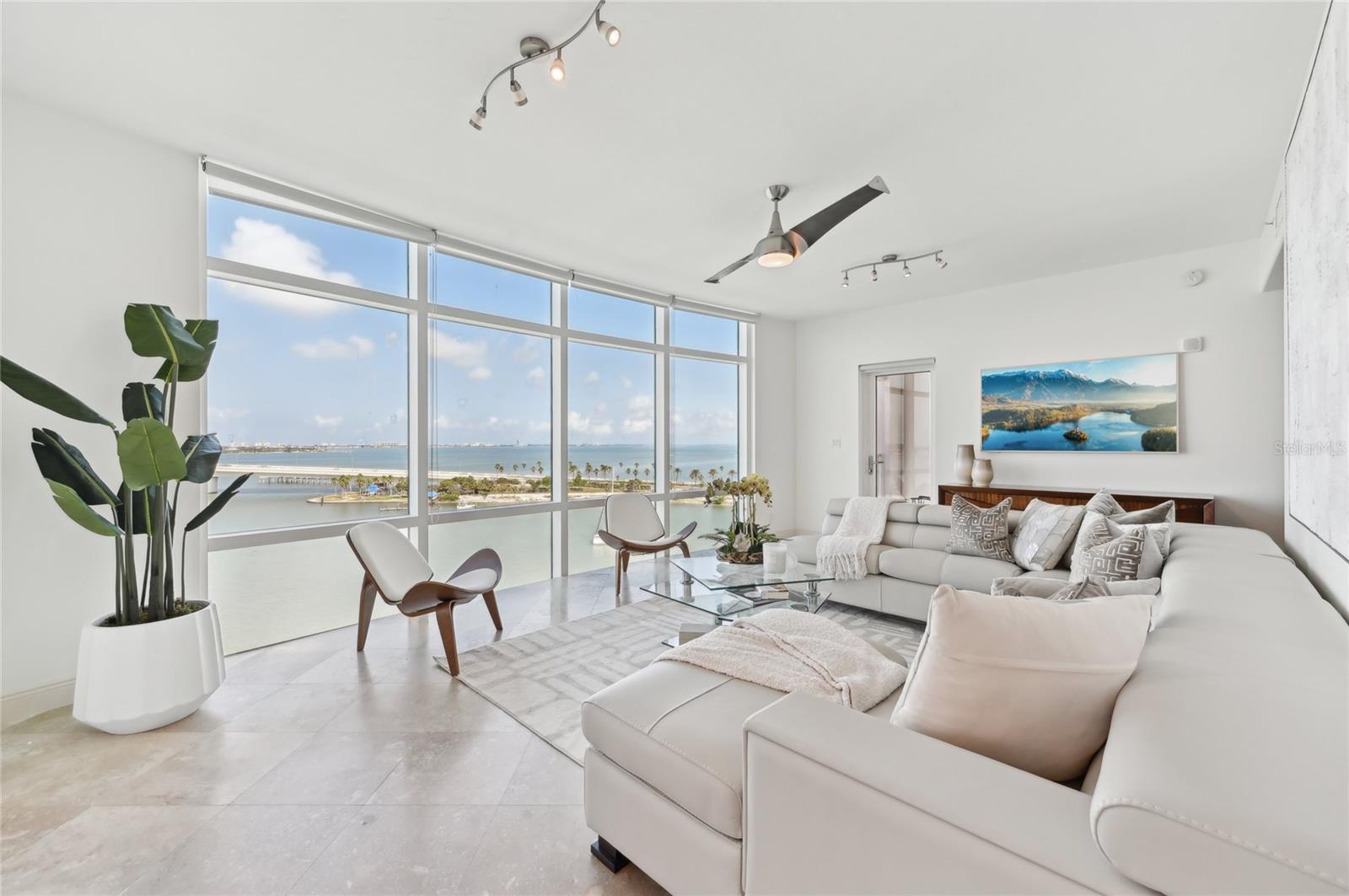 Experience the perfect blend of contemporary downtown living and breathtaking bay and city views in this rarely available three-bedroom-plus-media-room residence at Majestic Bay. Nestled in the desirable Golden Gate Point enclave, this exclusive and beautifully updated residence offers unparalleled access to Sarasota’s vibrant city center, with museums, fine dining, cultural events, and the Sarasota Bayfront just steps away. Occupying the entire eighth floor, this 3,000+-square-foot home offers the privacy and spaciousness of a single-family residence. Panoramic vistas of Sarasota Bay, the John Ringling Bridge, and the city skyline grace every room, complemented by stunning sunsets that enhance the living experience. The residence is accessed via a private elevator directly to the foyer, creating a seamless entry into this sophisticated getaway. The thoughtfully designed interior features travertine flooring, sleek stone finishes, and walls of impact windows that flood the space with natural light. The gourmet kitchen is equipped with wood-stained shaker-style cabinetry, granite countertops, stainless steel appliances including a Wolf gas range and built-in oven, an extended breakfast bar, and a charming breakfast nook with built-in desk. Its open-concept design flows effortlessly into the formal dining and living areas, ideal for entertaining or relaxed evenings at home. The primary suite is a tranquil escape, positioned in the northwest corner for privacy. This spacious retreat features an en-suite bathroom, expansive walk-in closet, and direct access to one of the home’s two terraces. Two guest suites and a versatile den are arranged in a split layout to ensure privacy for all. Two north- and south-facing terraces extend the living areas while showcasing stunning views of Sarasota Bay and the iconic John Ringling Bridge. Majestic Bay, a boutique community of just ten residences, offers exceptional amenities designed to elevate your lifestyle. Residents enjoy a club room, fitness center, heated pool and spa, and a summer kitchen on the pool deck. The rooftop terrace provides an ideal space for enjoying unparalleled city and bay views. Adding to its appeal, this residence includes its own deep-water dock and 10,000-pound lift, making it a boater’s dream.