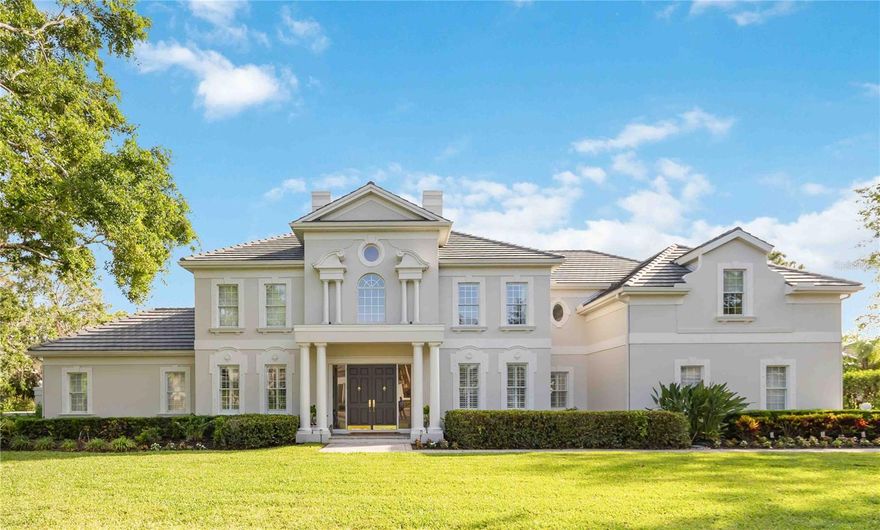 Introducing The Grand Estate at The Oaks Bayside—a true masterpiece of refined living within one of Sarasota’s most prestigious gated communities. Surrounded by majestic oak trees and lush tropical landscaping, this extraordinary residence offers the perfect blend of elegance, comfort, and privacy. A brand-new roof (2024) crowns this sprawling estate, while a pavered circular driveway leads to a spacious 3-car side-load garage. Stately columns welcome you to the grand double-door entry, where you’ll step inside to find gleaming marble floors, soaring ceilings, and plantation shutters that set the stage for timeless sophistication. The thoughtfully designed floor plan includes a private office with built-ins and French doors, and a flexible open space with a dramatic backlit tray ceiling—ideal for a formal dining room, music room, or library. The formal living room features a stunning picture window that brings the outdoors in, along with a cozy fireplace and direct access to the luxurious pool area. The chef’s kitchen is a true showstopper, complete with an aquarium window breakfast nook, expansive breakfast bar, dual sinks, center island, double wall ovens, and a butler’s pantry. It opens seamlessly into the family room, where sliding glass doors, a wood-burning fireplace, wet bar, and built-in desk create a warm and inviting space for everyday living and entertaining. The primary suite is a tranquil retreat with a sunlit sitting area, private access to the pool, and a spa-inspired en suite bath with a walk-in shower and soaking tub that overlook your private tropical paradise. Step outside to your own resort-style oasis, where a sparkling pool, separate spa, travertine deck, and covered patio offer the ultimate in outdoor living. With over 6,000 square feet of living space, this estate features 5 bedrooms, 5 full bathrooms, and 2 half baths, along with two newer A/C systems (2023). As a resident of The Oaks, you’ll have access to The Oaks Club’s world-class amenities, including two championship golf courses, tennis and pickleball courts, croquet, a state-of-the-art fitness center, and fine dining. Ideally located near top-rated Pine View School, Historic Spanish Point, Casey Key, and Oscar Scherer State Park, this home offers both tranquility and convenience. Don’t miss your chance to own this exceptional estate—schedule your private tour today and experience the luxury of life at The Oaks Bayside.