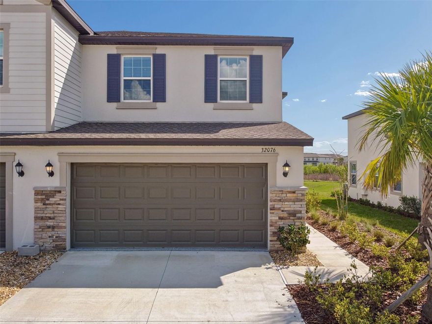 NEVER LIVED IN, FORMER BUILDER SALES MODEL, this beautifully upgraded townhome in the resort-style community of Mirada offers approximately 1,800 square feet of thoughtfully designed living space with 3 bedrooms, 2.5 baths, a second floor landing area, and a rare two-car garage. As a former model, the home showcases DESIGNER UPGRADES throughout, including custom accent walls, carefully selected finishes, and a polished presentation that immediately sets it apart. The open-concept main level features a spacious kitchen with abundant cabinetry, solid surface countertops, and a large center island that flows seamlessly into the dining and living areas, creating an ideal layout for both everyday living and entertaining. Sliding glass doors open to a covered lanai overlooking peaceful water views, offering a quiet outdoor retreat. Upstairs, the owner’s suite provides generous space, a large walk-in closet, and a well-appointed bath with dual sinks and a spacious walk-in shower. Two additional bedrooms, a full bath, and the second floor landing area create comfortable separation between living spaces. Mirada is known for its impressive resort-style amenities, including the well-known Crystal Lagoon, miles of walking trails, parks, playgrounds, and community gathering spaces designed for an active Florida lifestyle. The location also provides convenient access to Wesley Chapel’s premier shopping, dining, and entertainment, including Tampa Premium Outlets, The Shops at Wiregrass, and an abundance of top-rated medical facilities. Offering the rare opportunity to purchase a never-occupied former builder model, this home combines upgraded finishes, low-maintenance townhome living, and access to one of Pasco County’s most exciting master-planned communities.