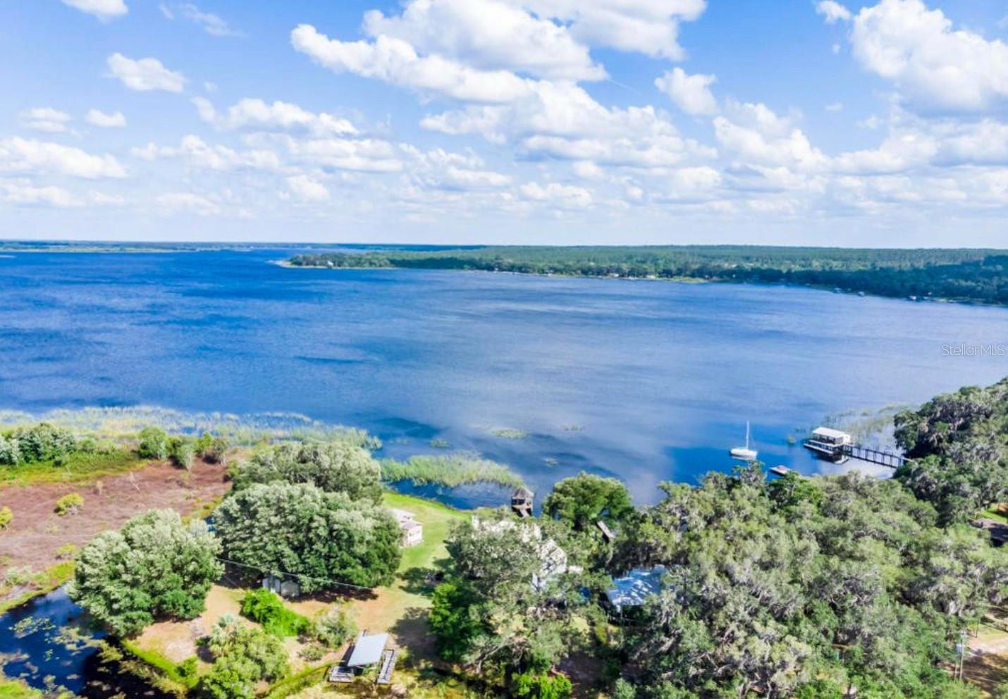Discover canal-front living at its finest—just minutes from the pristine waters of Lake Kerr, scenic ATV trails, crystal-clear natural springs, and endless hiking adventures. This beautifully maintained property blends comfort, charm, and the perfect touch of Florida outdoor living.
Gated by a secure chain-link fence, the manicured grounds feature lush, emerald-green grass and thoughtfully designed landscaping that set the tone for what’s inside. A versatile 9x21’ building, complete with electric and partial drywall, offers the ideal space for a workshop, studio, or private retreat. An attached 11x21’ covered parking area adds both convenience and function.
A graceful concrete walkway guides you to a 6x14’ screened porch where tranquil canal views invite you to unwind with morning coffee or evening sunsets. Step inside to a welcoming foyer with durable vinyl flooring that flows into a warm and inviting kitchen—rich with cabinetry, ample counter space, and all appliances included. Adjacent, the sun-filled dining area and elegant living room with bay windows create the perfect space for entertaining or simply enjoying the view.
Both bedrooms are generously proportioned, and the bathrooms feature tasteful updates for modern comfort. With a durable metal roof replaced in 2016, this home offers peace of mind along with its inviting charm.
Here, every day feels like a getaway—where water, wildlife, and adventure are always just steps from your door.