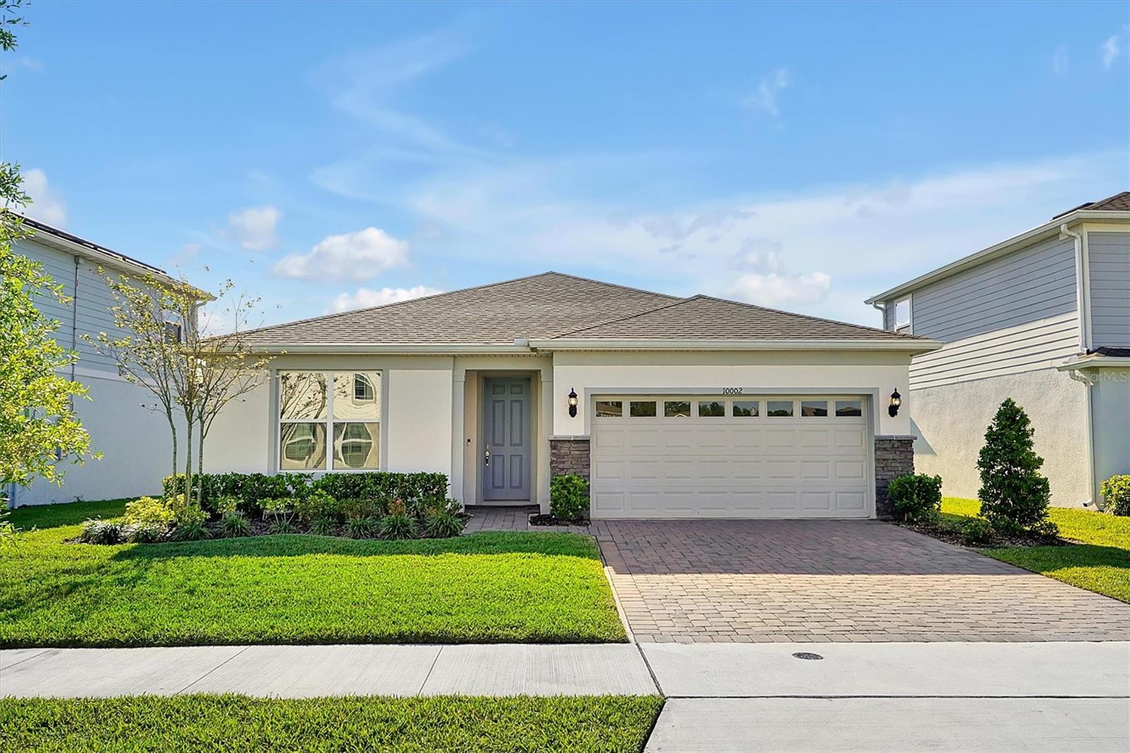 Stunning single-story home, with breathtaking lake and lush green views. The Covered lanai features an outdoor sink and electric screens—perfect for year-round entertainment. The kitchen is equipped with premium KitchenAid appliances, including a convection oven. Pre-wiring for an audio system. A state-of-the-art alarm system adds peace of mind. The spacious master suite boasts a luxurious walk-in bath with grab bars for added comfort. This home is also equipped with a special air filtration system for decontamination, ensuring cleaner air, which is ideal for allergy sufferers. Functional kitchen island with elegant quartz countertops, and the laundry room is thoughtfully designed with custom cabinetry and a utility faucet for added convenience. The garage features epoxy flooring for a polished finish. The lot was purchased at a premium for its exceptional location, offering easy access with no homes directly in front or behind. A strategically placed hydrant prevents cluttered parking, within easy walking distance to the community pool, park, and mailboxes. Additionally, with Orlando’s high summer temperatures, the sleeping rooms are ideally oriented eastward, allowing for refreshing morning sunlight while avoiding the intense afternoon heat. Nestled in a vibrant community, this home is just 15 minutes from downtown Orlando and Lake Nona. Experience the perfect blend of luxury, style, and prime location.