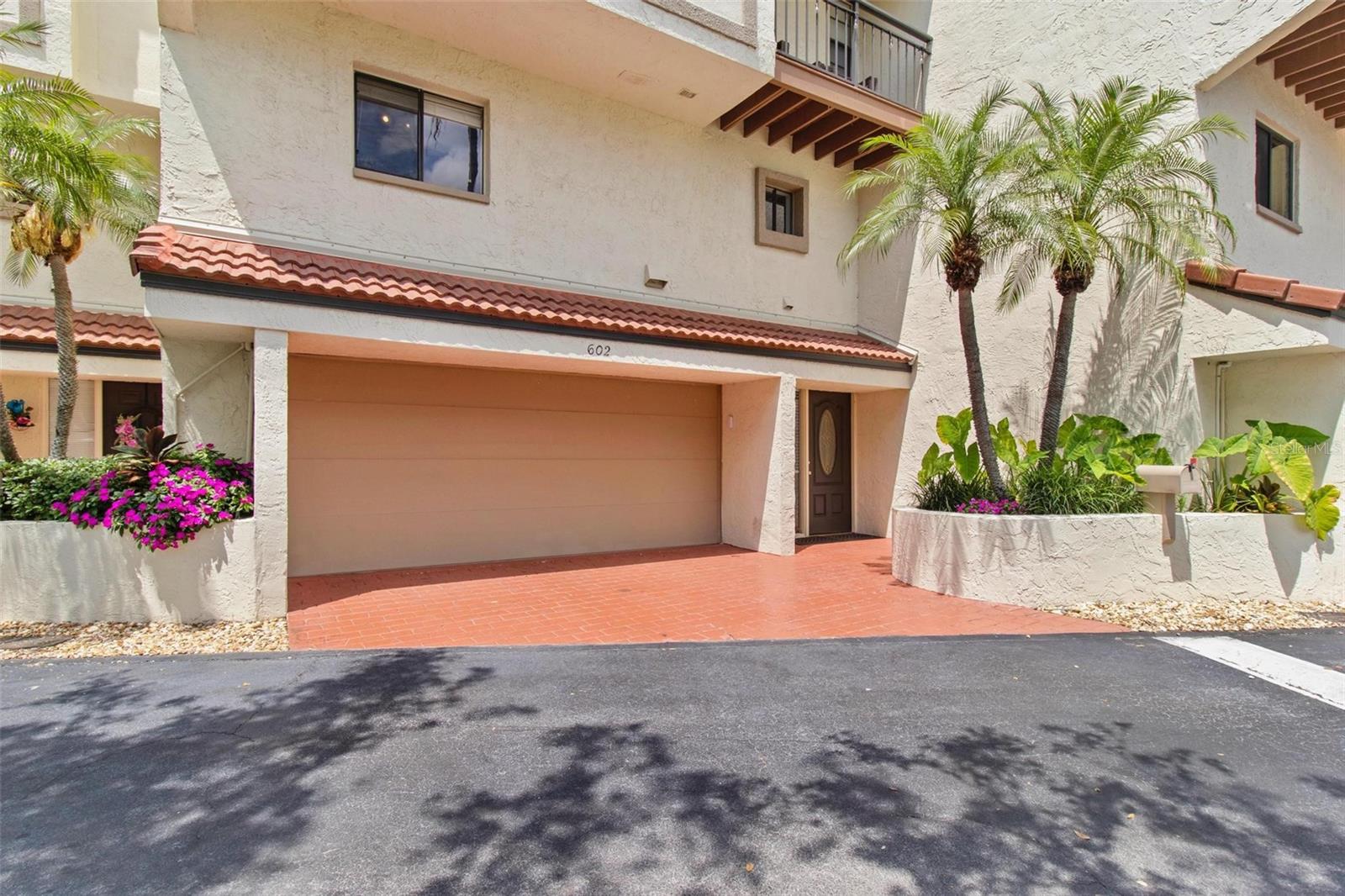 Introducing the Village on Island Estates, your gateway to an idyllic waterfront lifestyle in Clearwater Beach. This beautifully renovated townhouse features 2 bedrooms and 2 and a half baths, complete with a side-by-side 2-car garage and a spacious enclosed bonus room that offers endless possibilities. The second level showcases an inviting open floor plan enhanced by vaulted ceilings, a cozy fireplace, and sliding doors that lead to a private outdoor deck, perfect for entertaining amid tropical surroundings. The deck, complete with space for grilling and seating, offers convenient access to one of the two community pools. The thoughtfully designed kitchen boasts a bonus area ideal for a home office or butler’s pantry, along with a full laundry room equipped with an extra refrigerator and laundry sink. Ascend the stairs to the third floor, where both generously-sized bedrooms serve as master suites, each with ensuite baths, ample closet space, and private balconies. Living in this well-maintained community provides peace of mind with services including lawn care, pool maintenance, and on-site management. Recently passing a Milestone Inspection with Fully Funded Reserves and newly replaced roofs in 2023, this pet-friendly oasis features lush gardens, community-maintained boat slips for rental, and much more. Experience the unparalleled benefits of living at the Village on Island Estates – it truly is paradise waiting for you!
