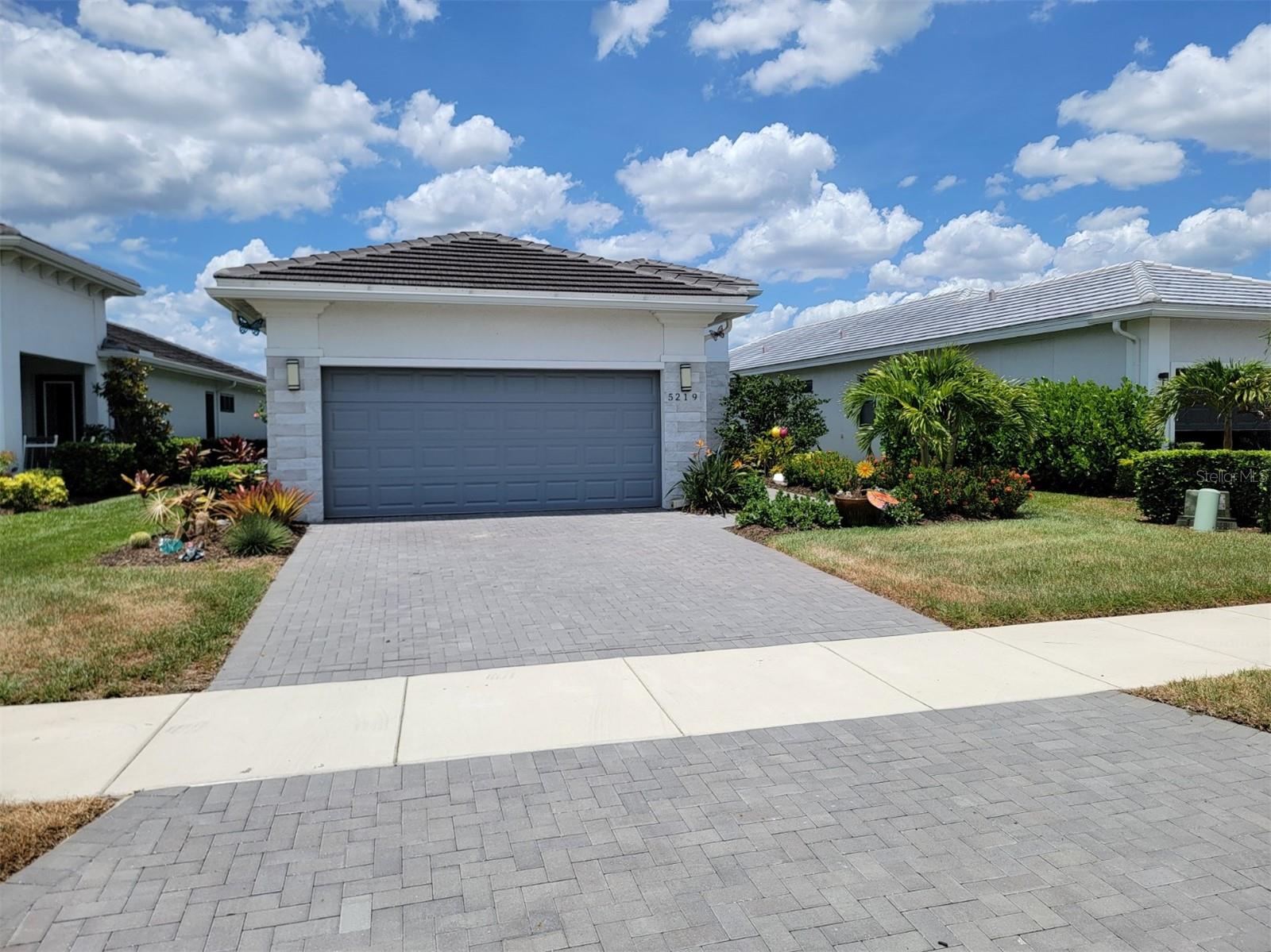 Cresswind at Lakewood Ranch 55+ Community home for sale with great lake views. Home has a saltwater pool with a gas heater installed. The kitchen has a quartz waterfall countertop and backsplash, stainless steel appliances including a gas range, and refrigerator with built in Keurig coffee maker, and modern cabinetry. The breakfast area is perfect for casual dining. Light fixtures from Restoration Hardware and others complement every space. The Great Room is lined with glossy white porcelain tiles, tray ceilings, recessed lighting, and ceiling Sonos speakers throughout (including the Lanai) promote a relaxing environment. The Den includes a built-in bookcase and a faux brick wall. The Master bedroom offers wonderful lake views, a frameless shower with dual vanities. One of the two closets has an additional hot/cold hookup to place a washer /dryer or pet wash station. The second bedroom at the front offers privacy next to another full bath. The lanai and pool are surrounded with faux grass and has a tv hookup and a natural gas hookup for grills. Each bedroom has luxury vinyl flooring. The south-facing orientation allows for great light and minimizes heat from the afternoon sun. The laundry room is located next to the garage entrance with access to the upgraded HVAC system that includes installed UV lighting to combat dust and mold. Additional highlights include a 2-car garage equipped with two overhead racks, a workstation, a wall-mounted tool system, custom blinds, shutters as well as Shelf Genie drawers. Cresswind at Lakewood Ranch offers 55+ residents an active resort-style lifestyle a private clubhouse, pickleball and tennis courts, a dog park, scenic lighted trails, a resort-style pool and spa, a resistance pool, bocce courts, and an outdoor plaza with food truck events and social spaces. The full-time Lifestyle Director provides access to many clubs and live music throughout the year. Cresswind includes a cutting-edge SmartFIT Training Center, powered by EGYM, allowing for efficient 20-minute workouts just twice a week.
